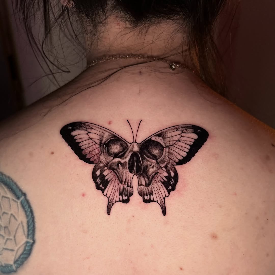 Skull butterfly fine line tattoo on the back by Tattoo Artist Vanessa