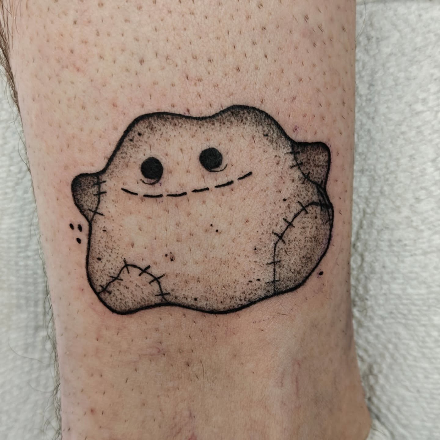 Stuffed animal black and grey tattoo on the forearm by Meg