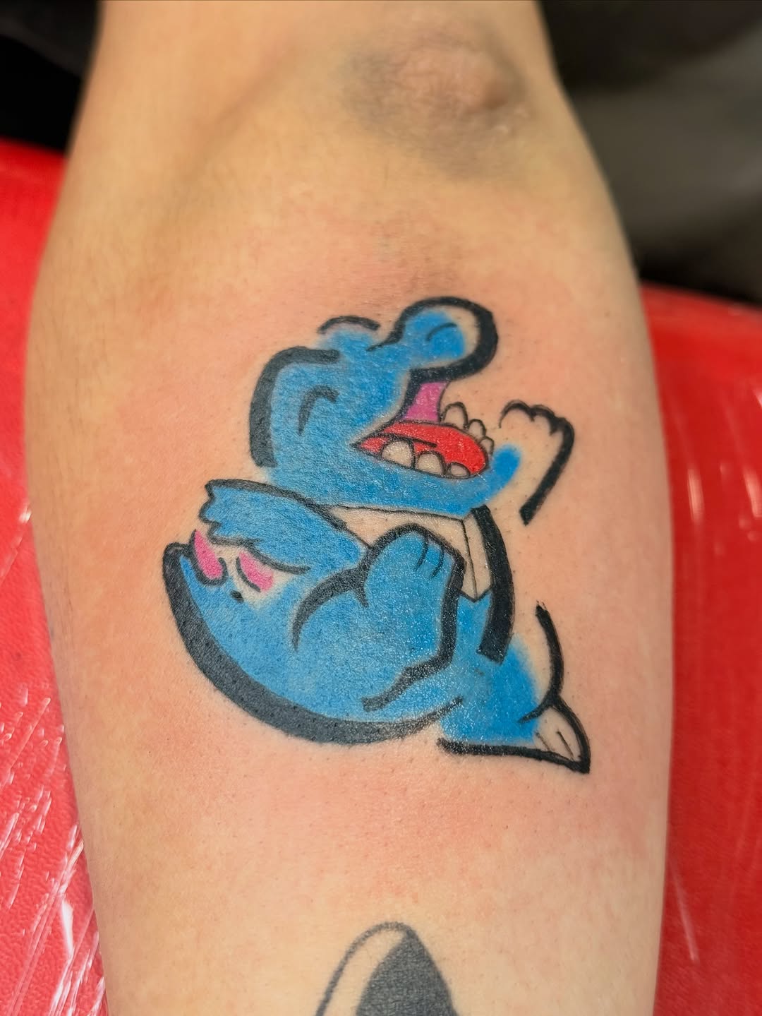 Blue cartoon character new school tattoo on the forearm by Jones Eric