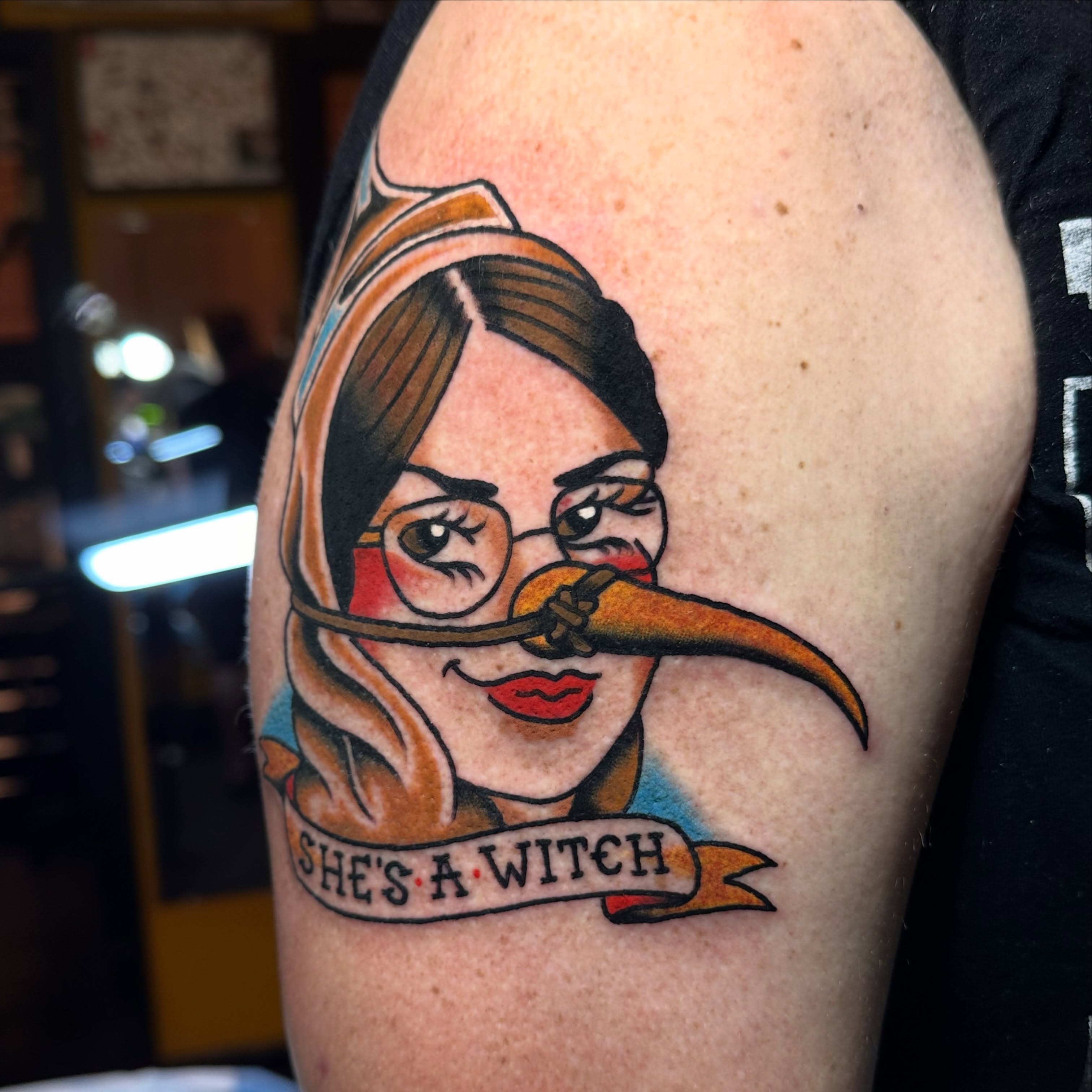 Woman with long nose American traditional tattoo on the upper arm by Kiki Painmaker Trad Tattooer 🧨