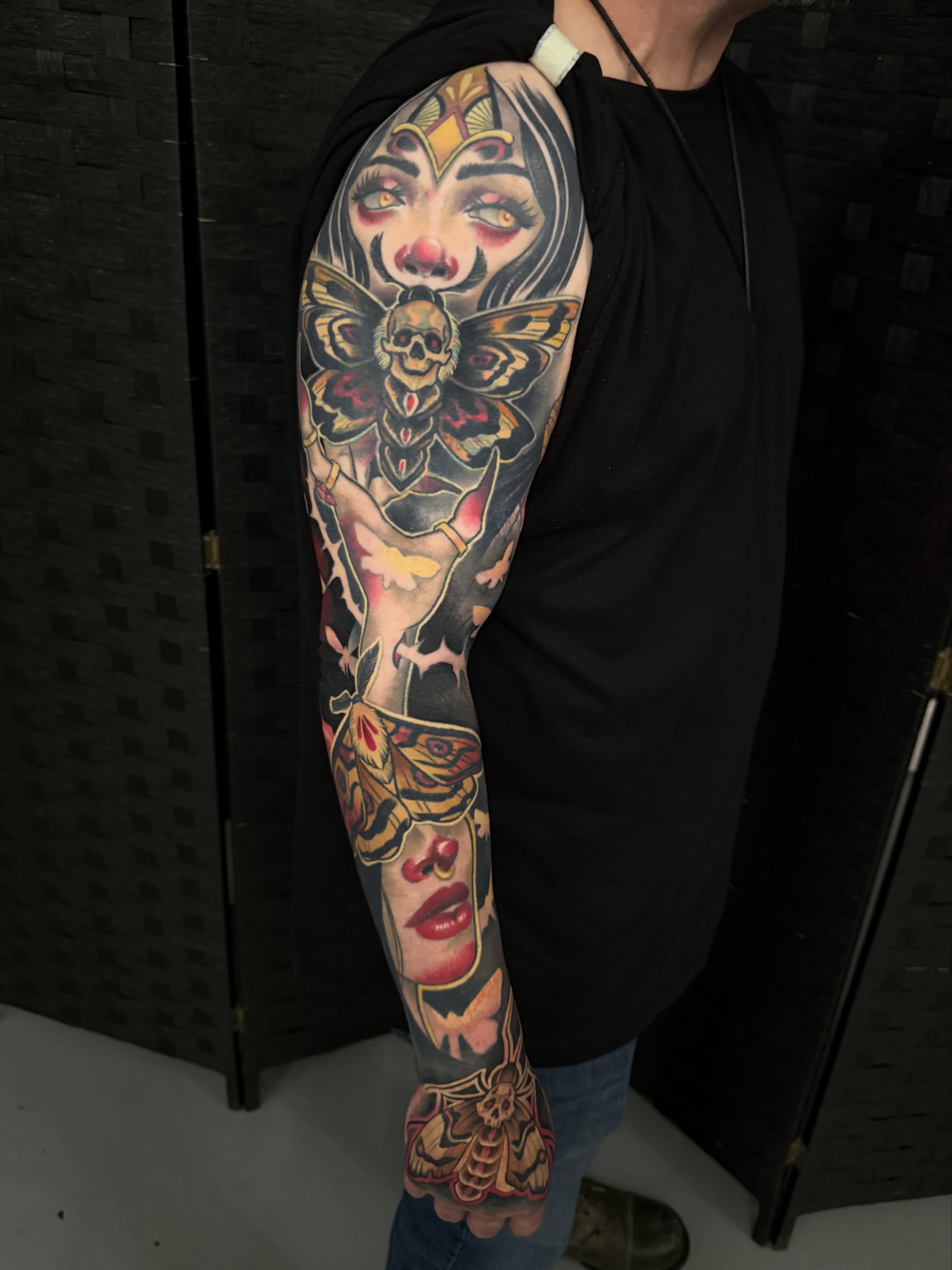 Woman with moth American traditional tattoo on the upper arm by Sam Castro