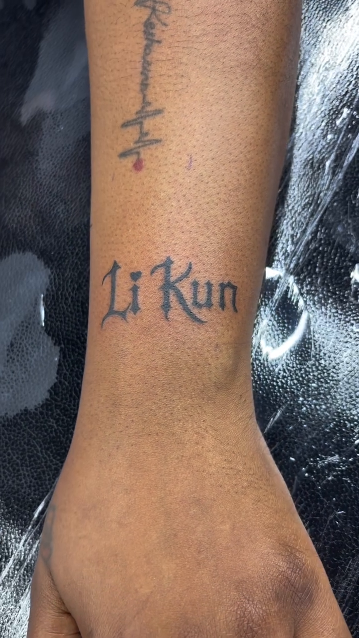 Li Kun lettering with heartbeat tattoo on the forearm by Art Plug