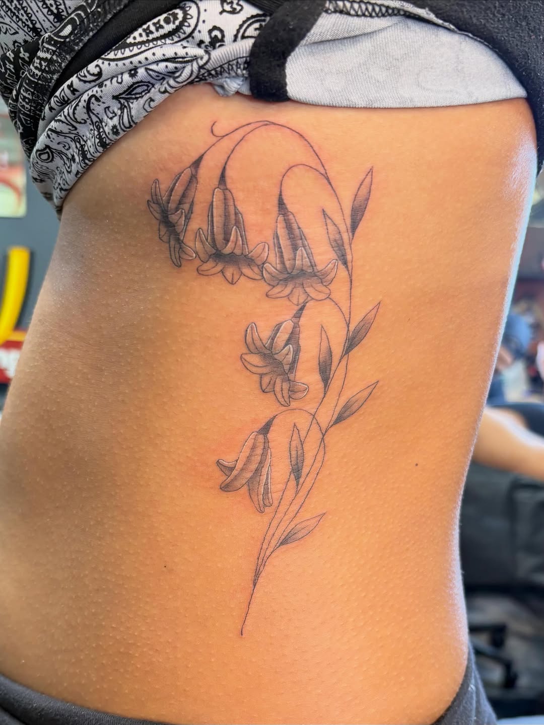 Bellflowers fine line tattoo on the ribs by alana khounmeuang