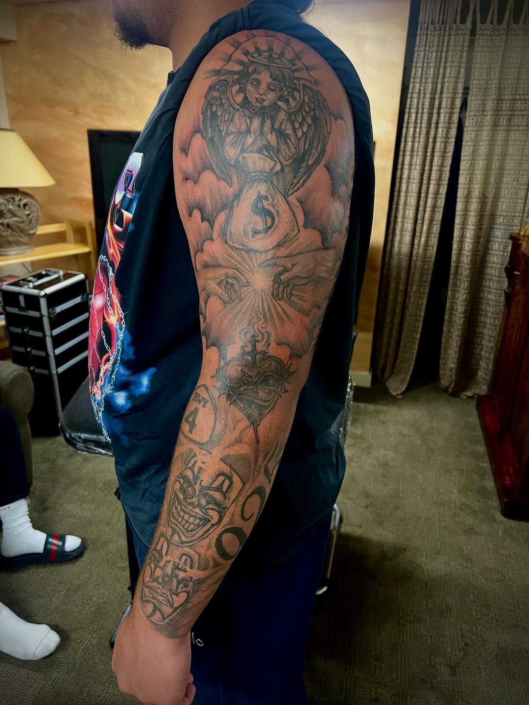 Chicano tattoo on the upper arm by Jelani