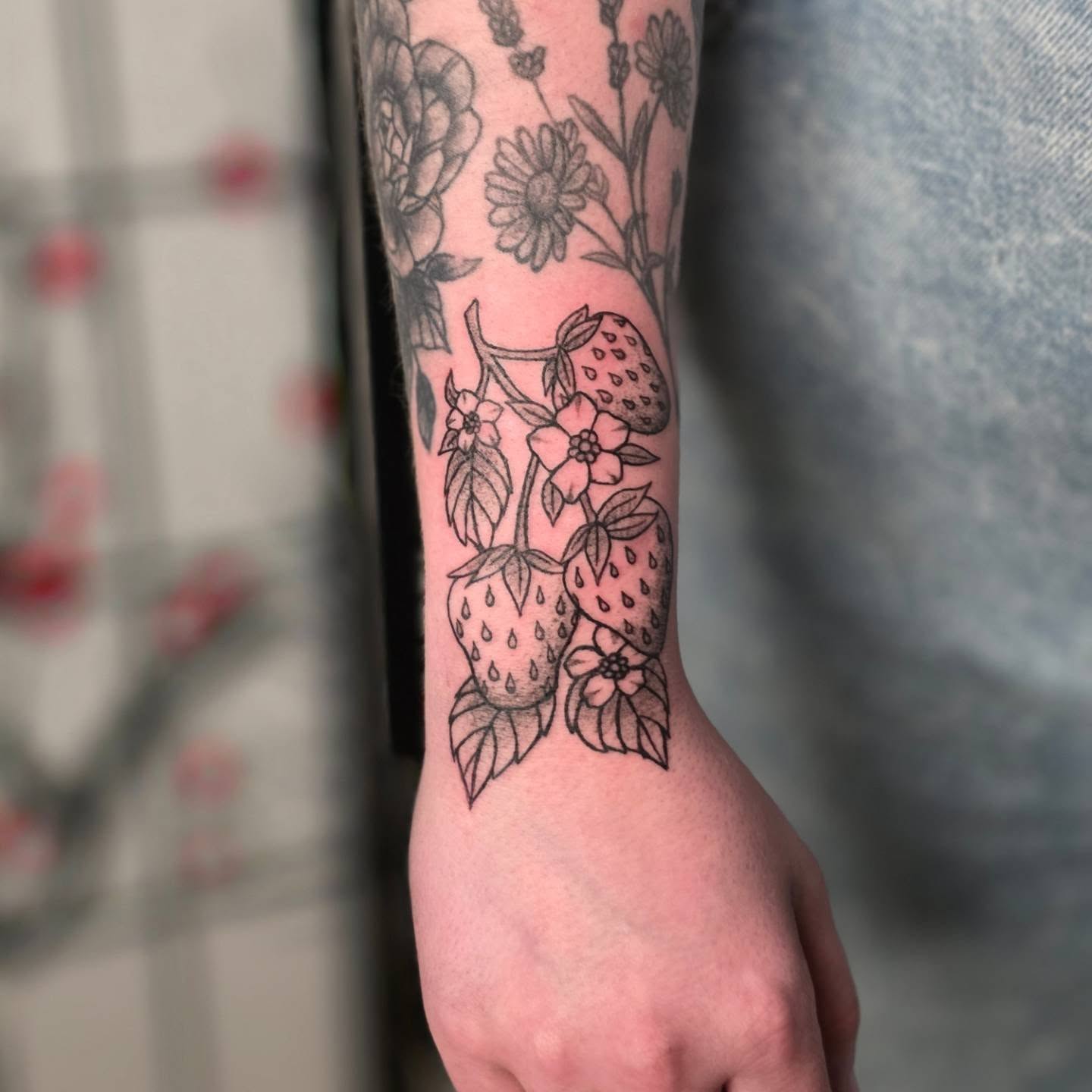 Strawberries and flowers black and grey tattoo on the forearm by Bryan "Yogi" Fuhs