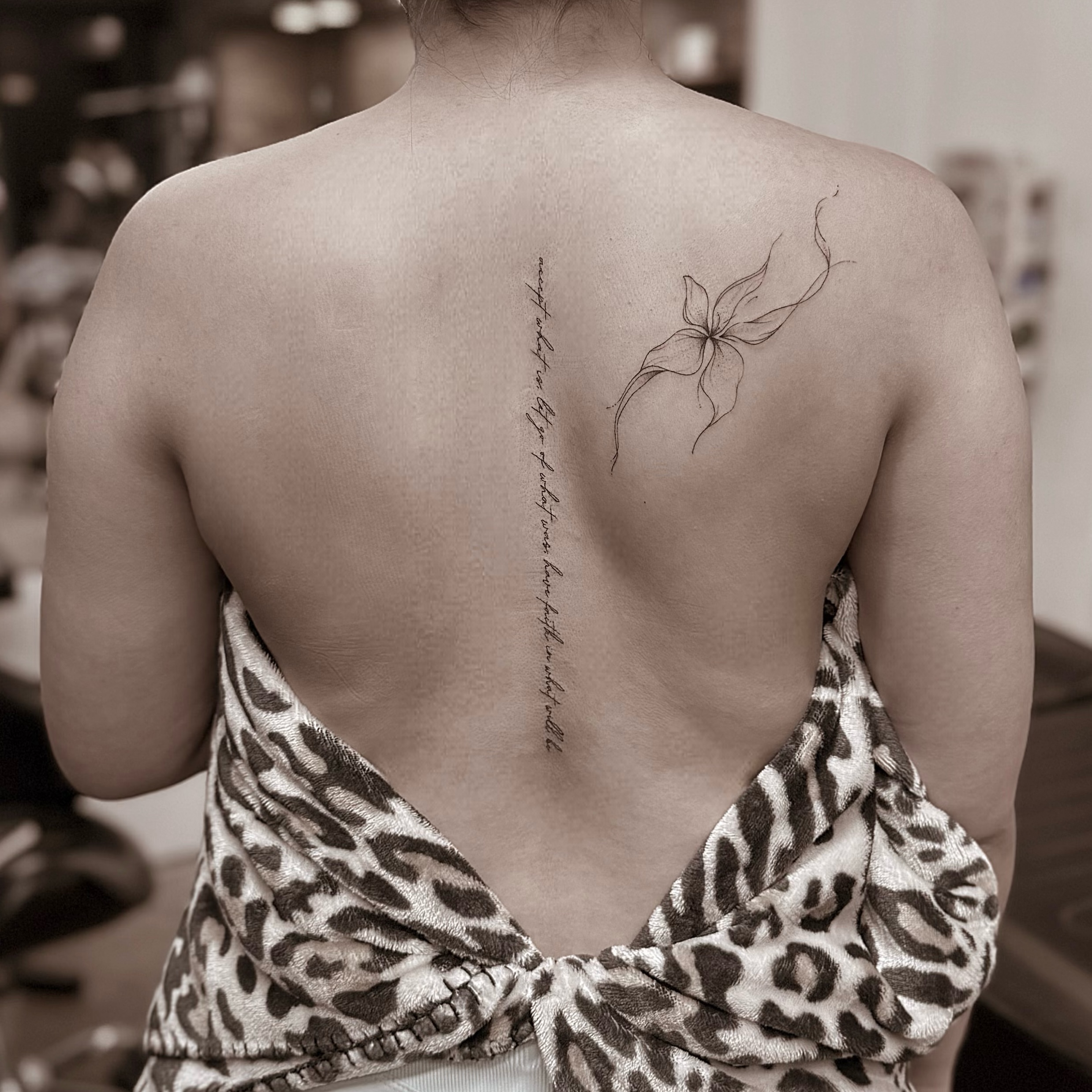 Flower fine line tattoo on the back by Chanel Picquelle, Nashville, Tennessee