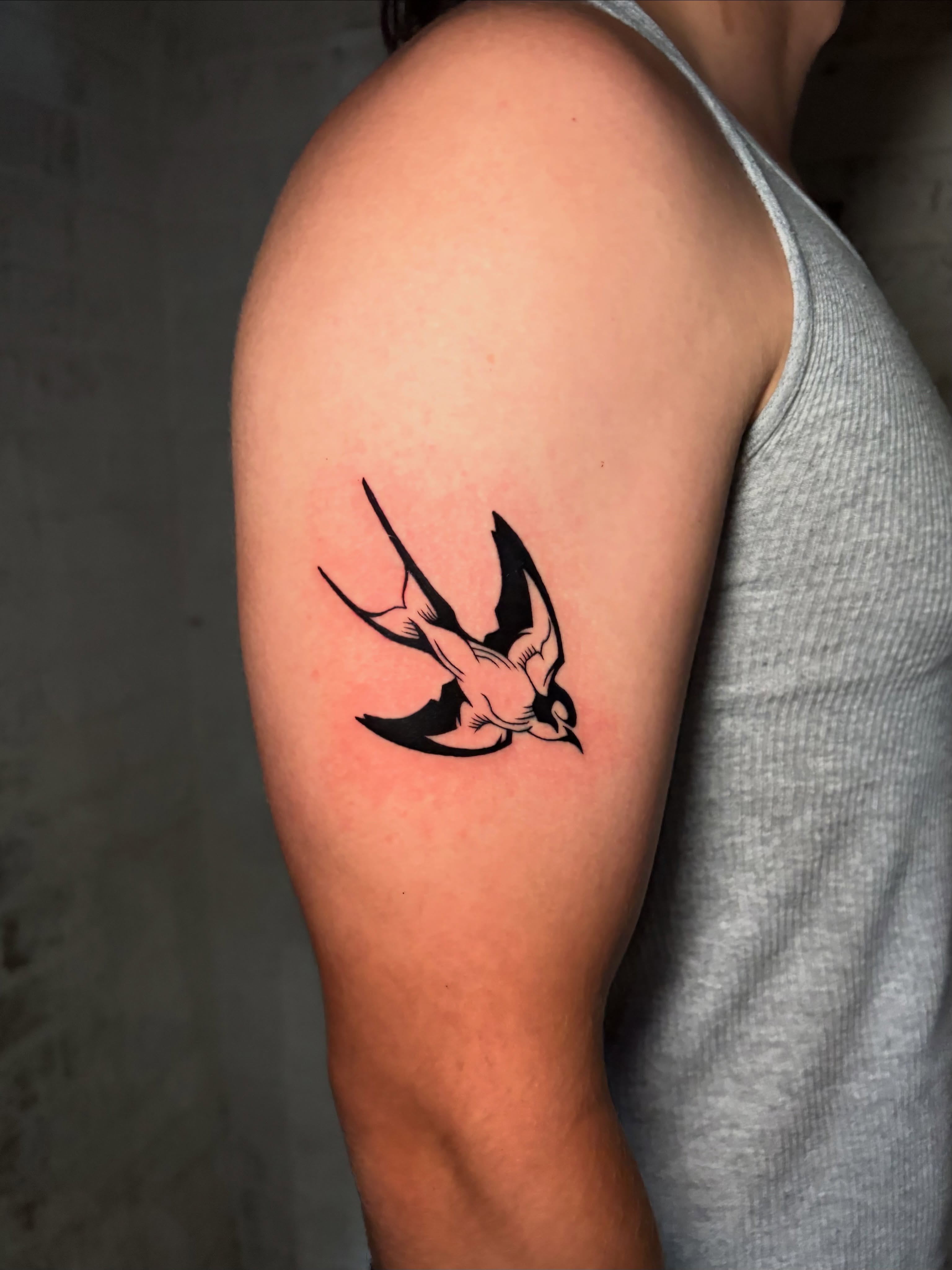 Swallow black and grey tattoo on the forearm by Musa Selman