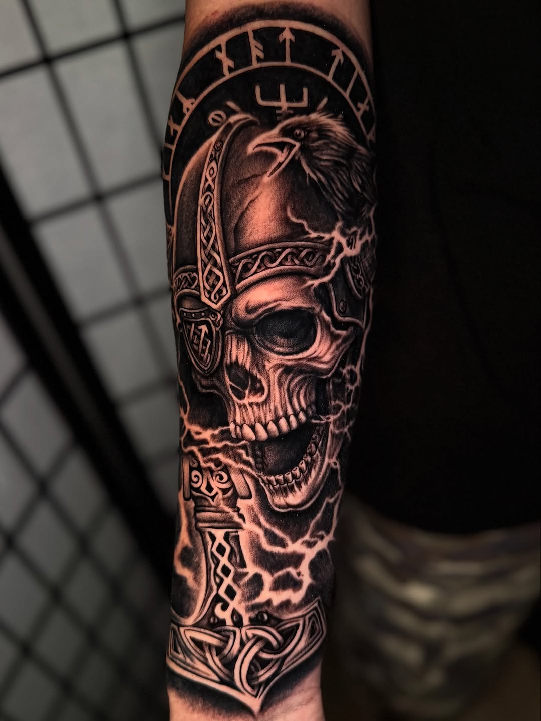 Viking skull with raven and hammer realism tattoo on the forearm by Anthony Ramirez