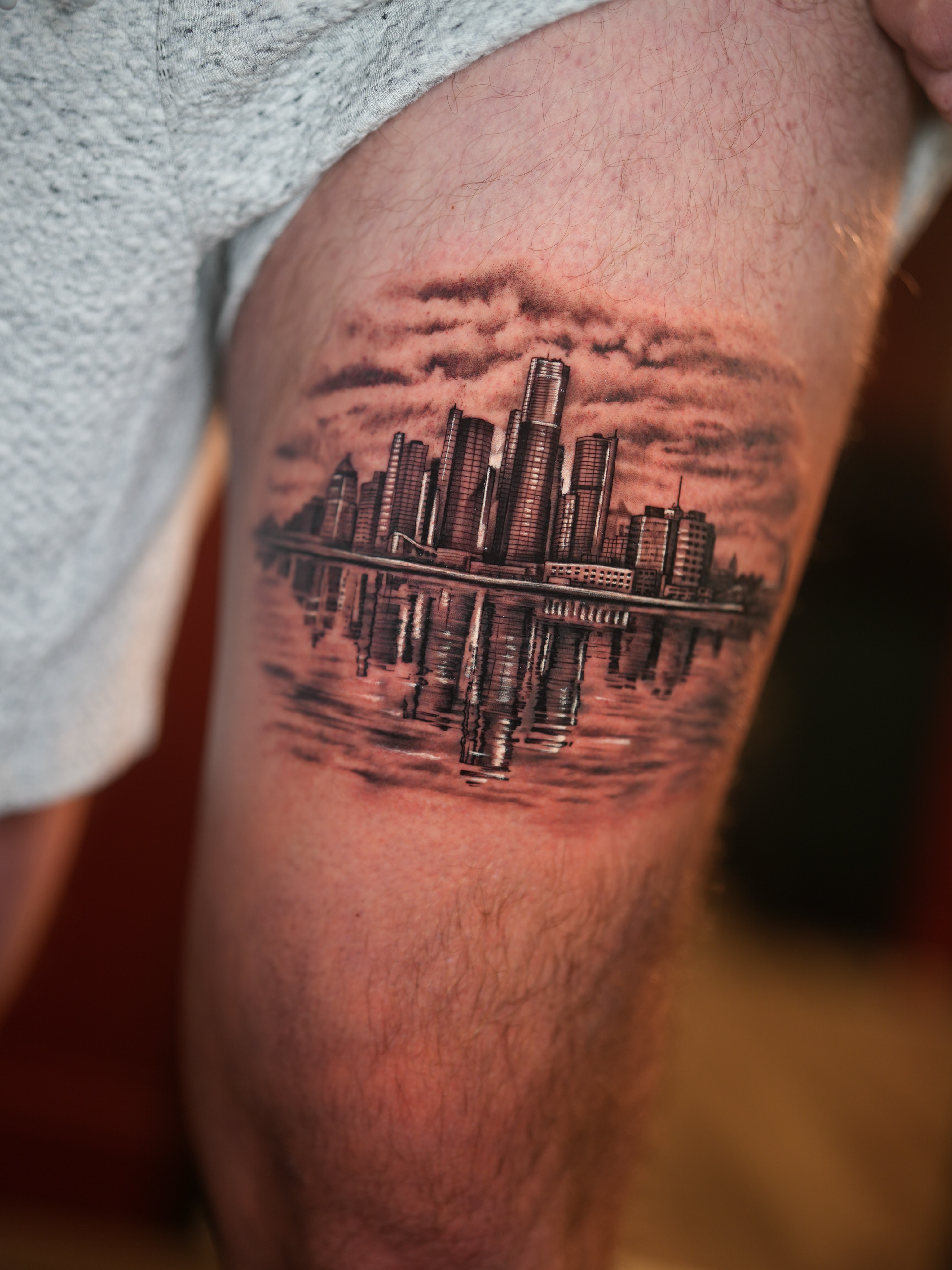 City skyline realism tattoo on the thigh by Franz Muñoz
