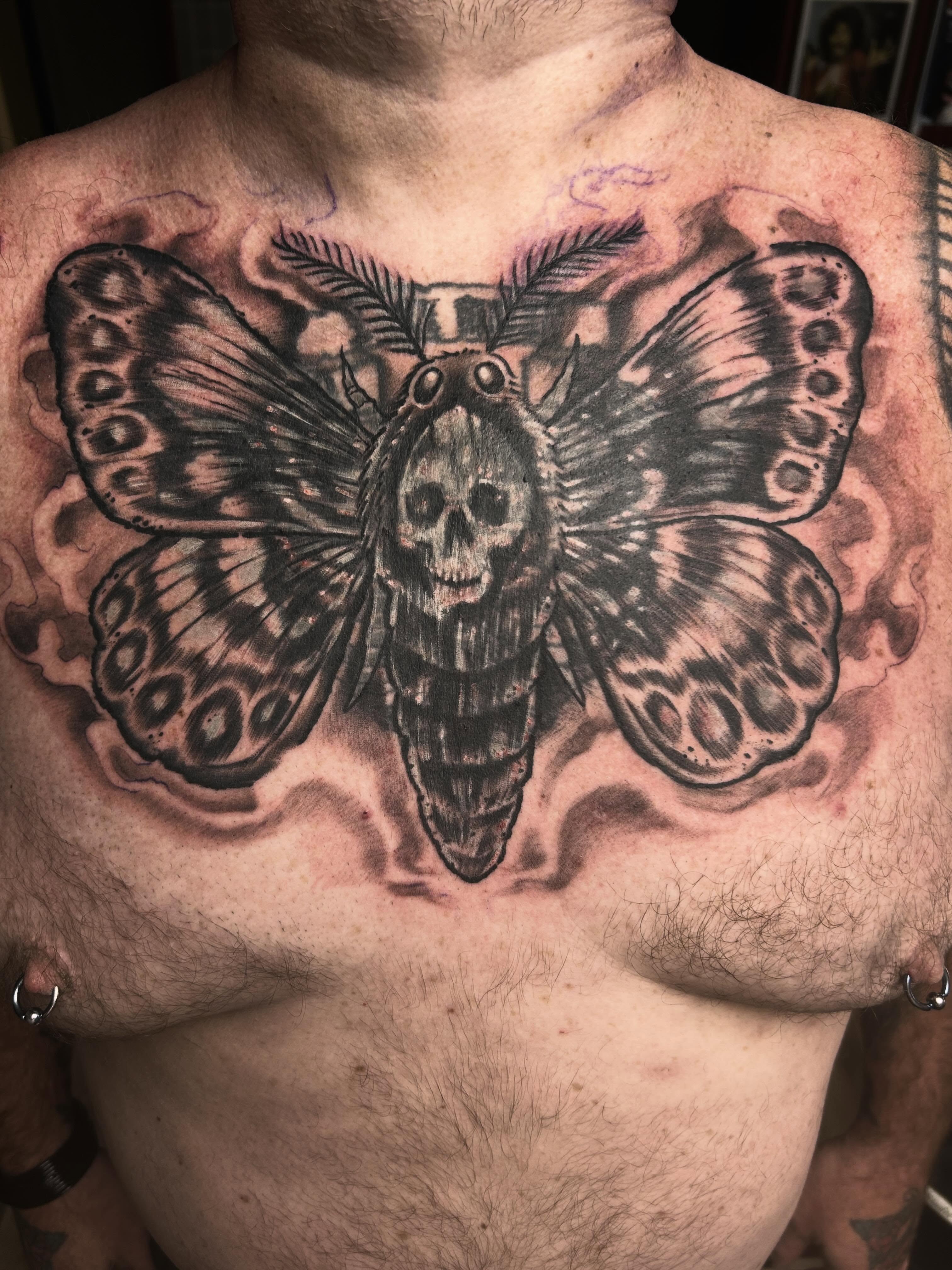 Butterfly skull realism tattoo on the chest by Dan Schuster