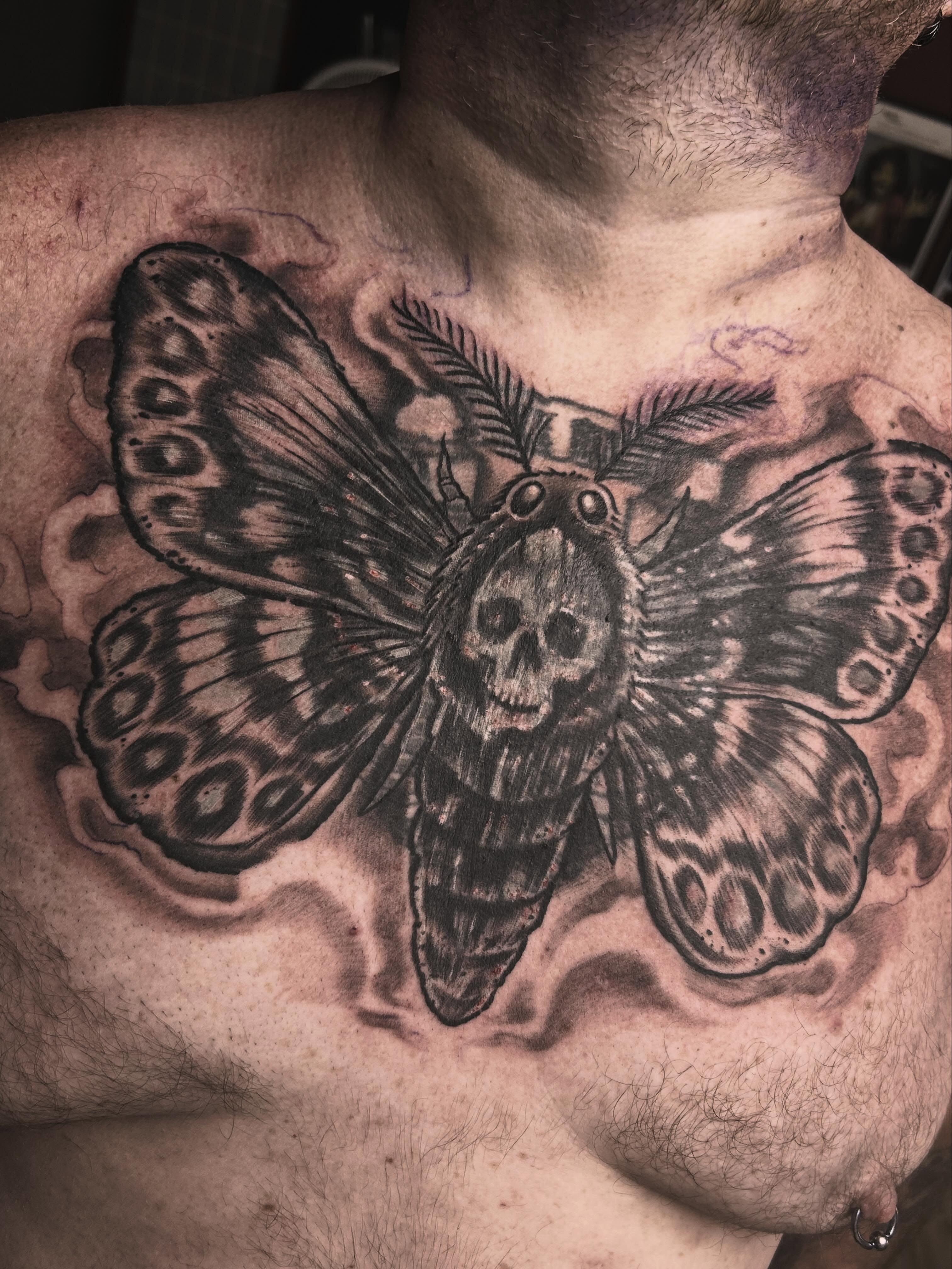Butterfly with skull realism tattoo on the chest by Dan Schuster