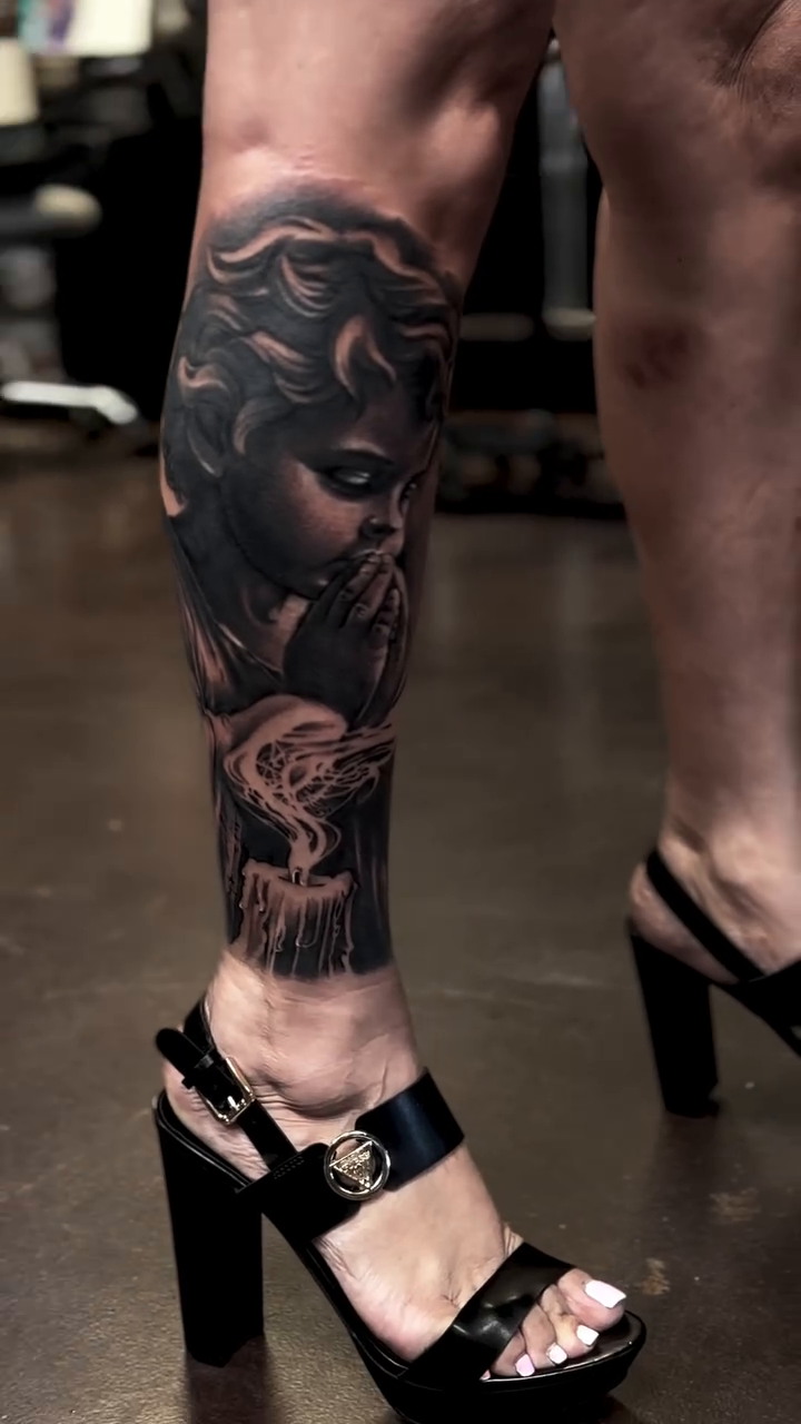A praying angel with smoke surrealism tattoo on the calf by Raul Rodriguez