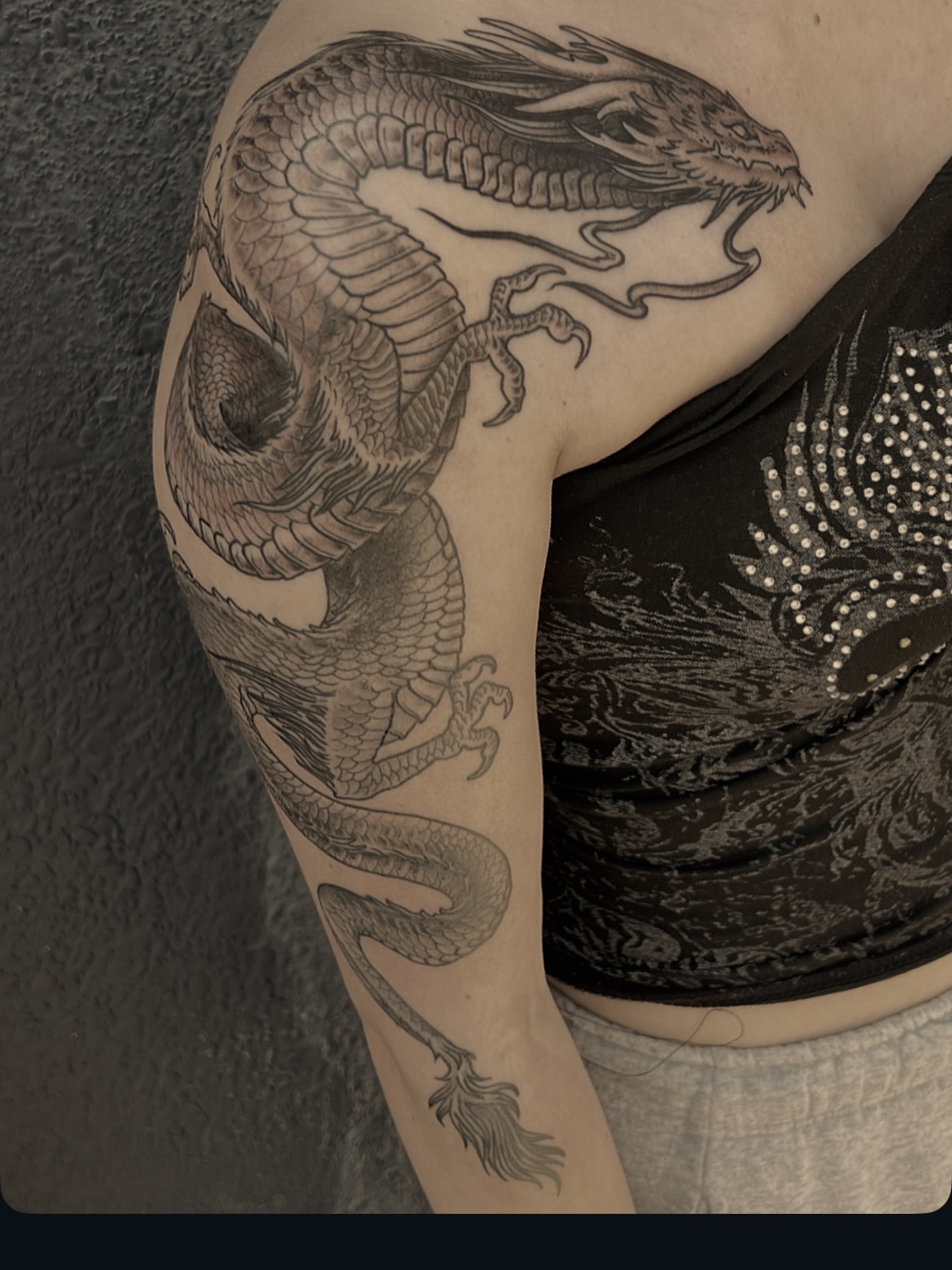 Dragon realism tattoo on the upper arm by Andrea Patterson