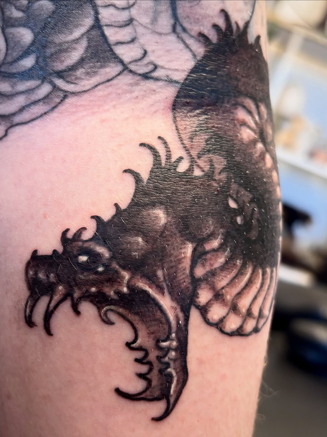 Dragon head realism tattoo on the upper arm by Cricket Elijah Cervidae