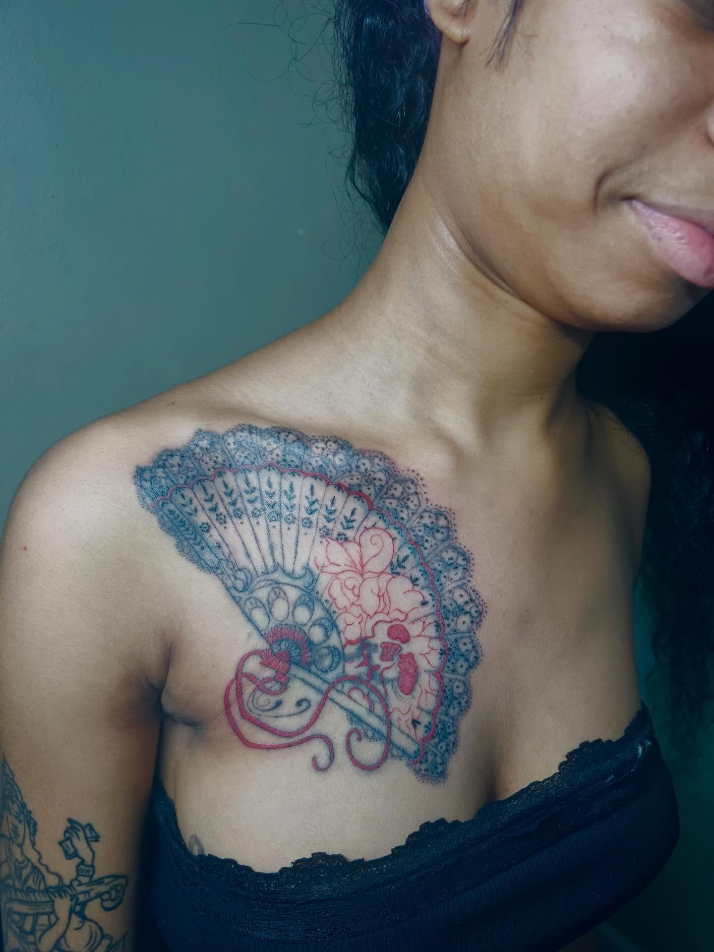 Fan and floral ornamental tattoo on the chest by K.L Tattoo Uptown