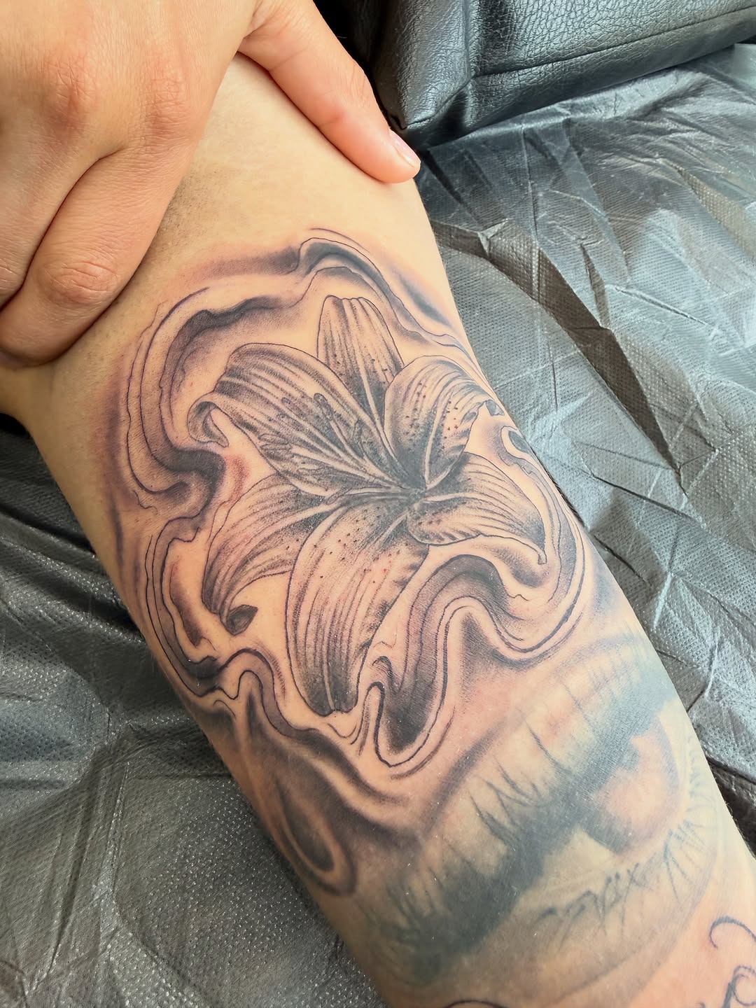Lily flower with smoke fine line tattoo on the forearm by Ricky Sanchez, Duncanville, Texas