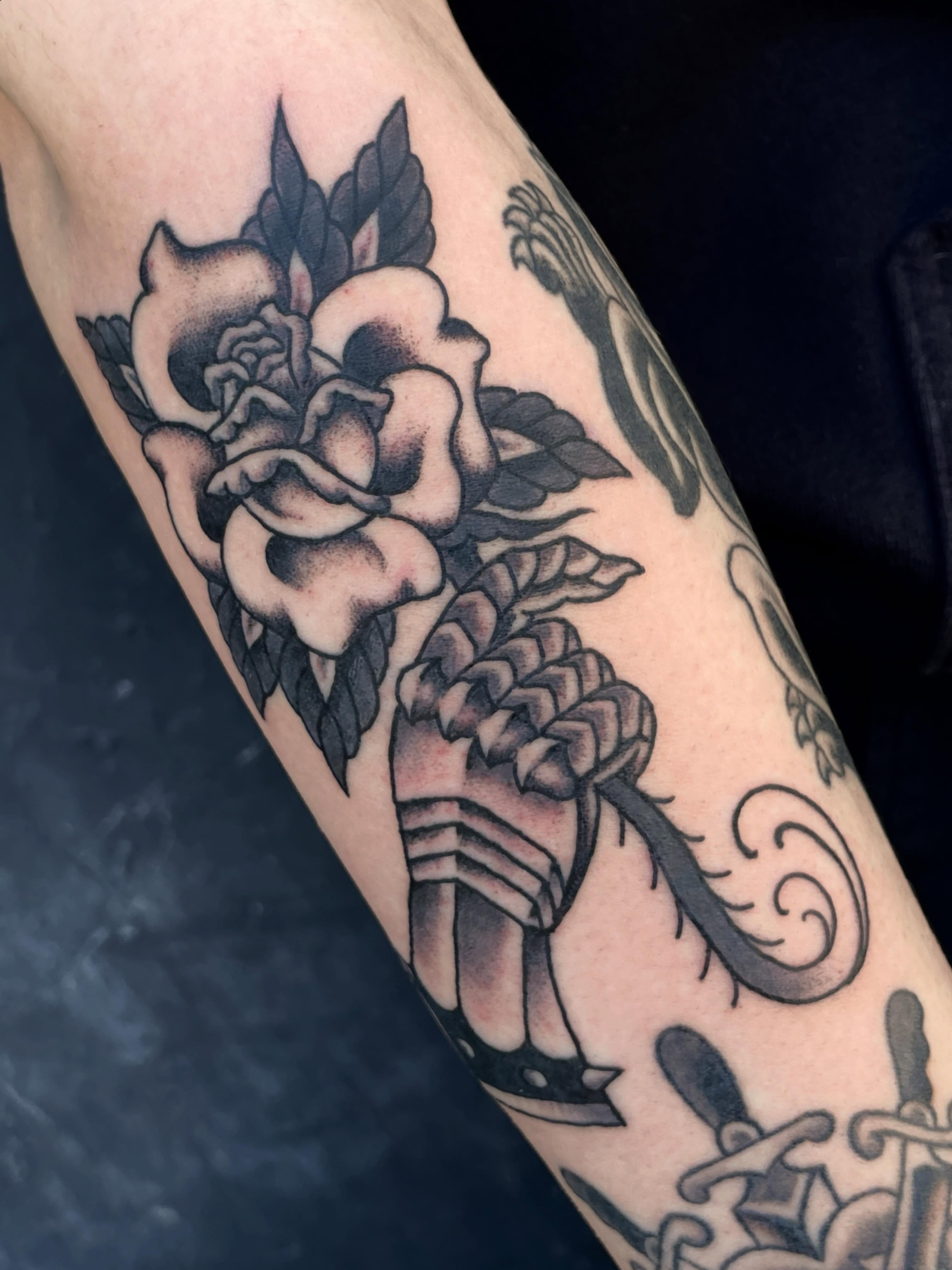 Roses and skull American traditional tattoo on the forearm by Nick Wallin