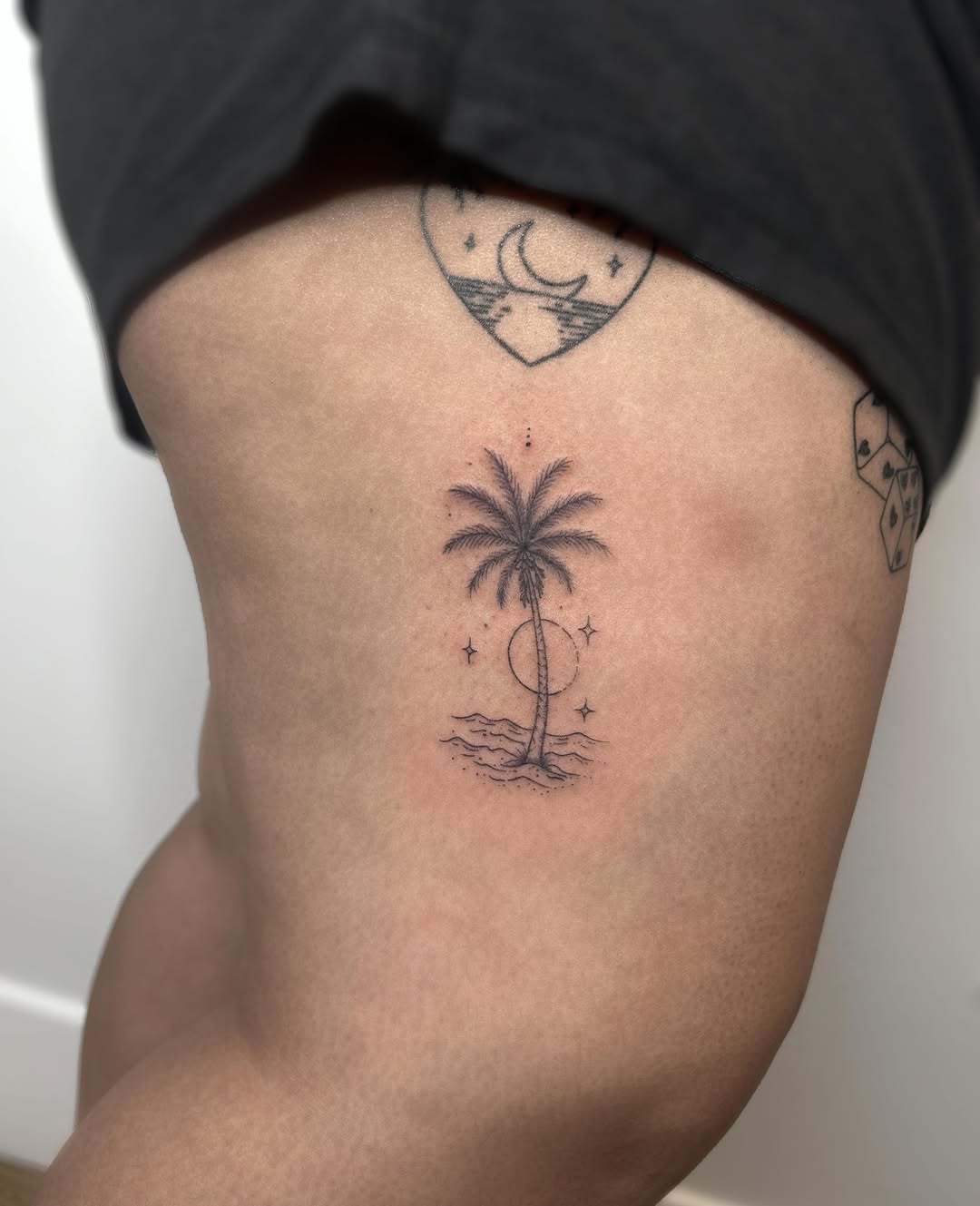 Palm tree with sun and waves fine line tattoo on the ribs by 𝒜𝓇𝓉𝒾𝓈𝓉 𝒟𝒶𝒾𝓈𝓎 ♡