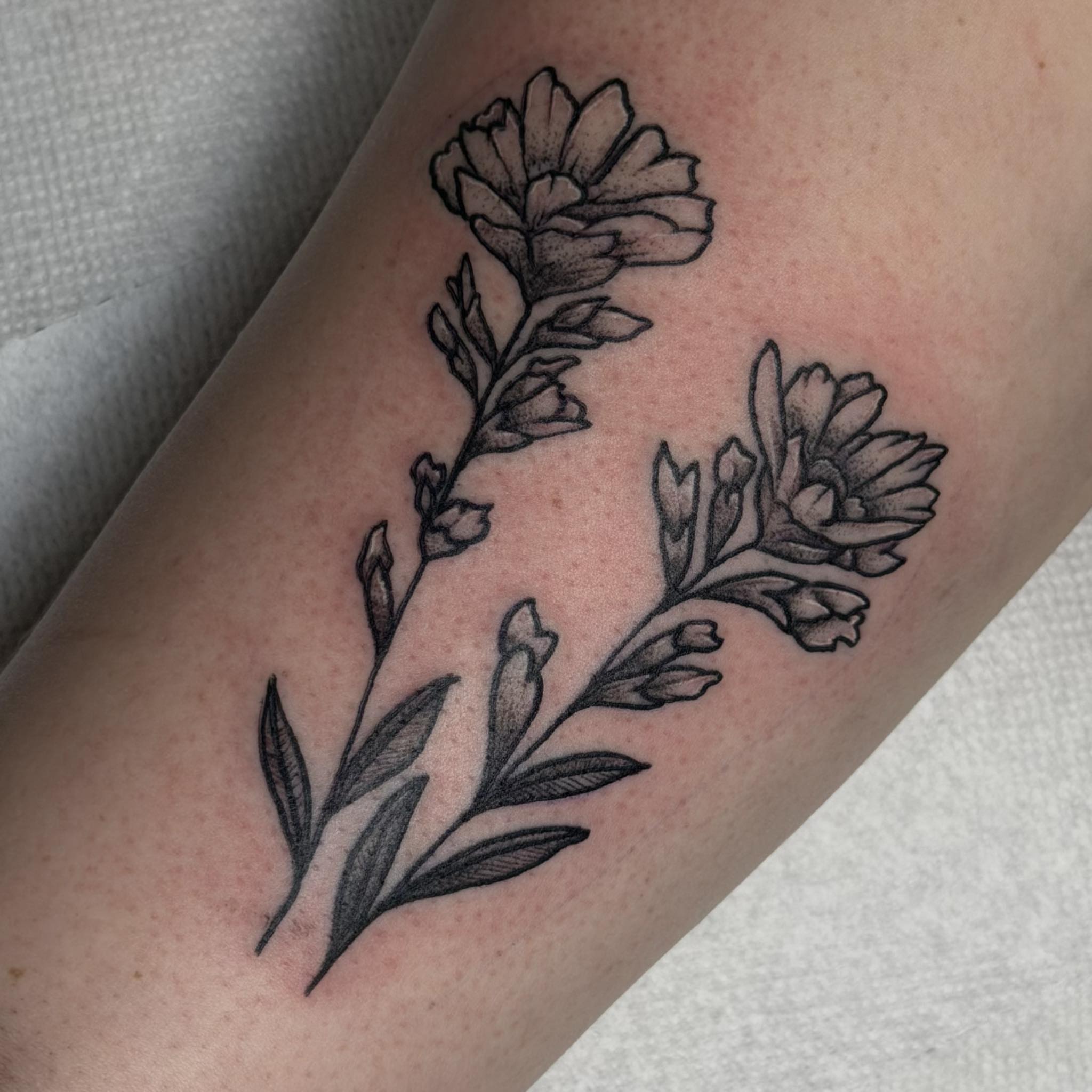 Flowers black and grey tattoo on the forearm by Kenneth Prince