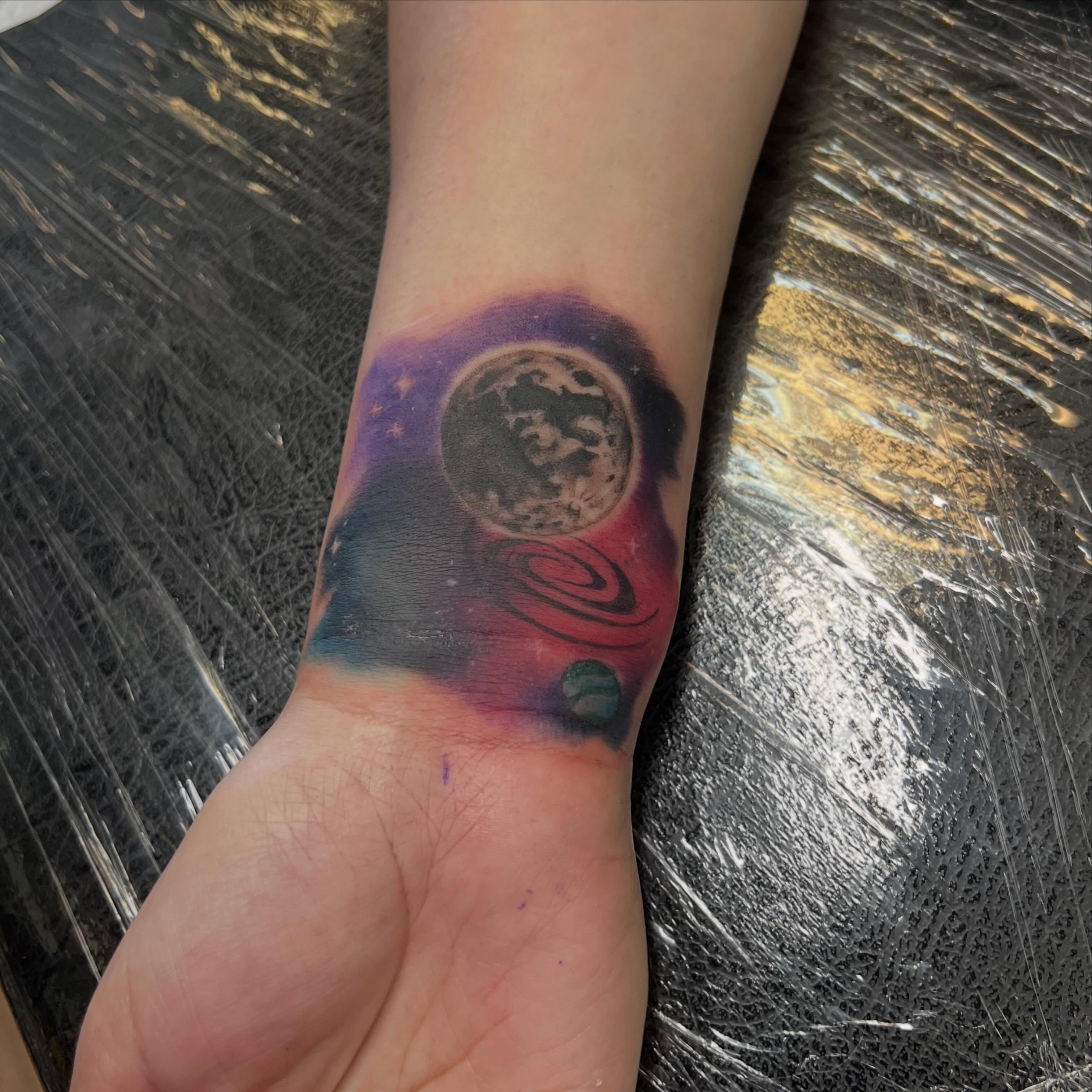 Space-themed dotwork tattoo on the forearm by Bailey Goodwin, Ankeny, Iowa