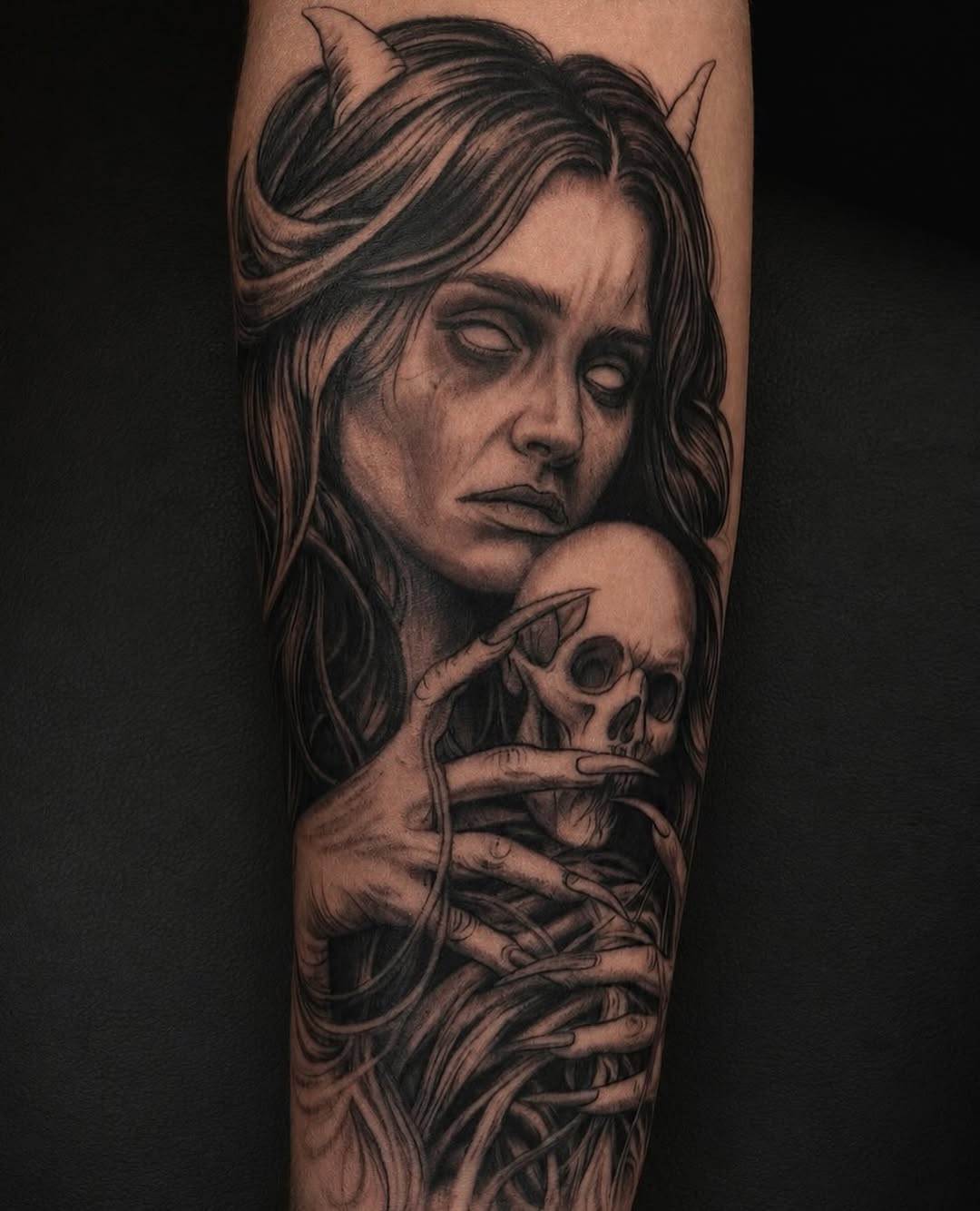 Demonic woman holding a skull realism tattoo on the forearm by Jayden A