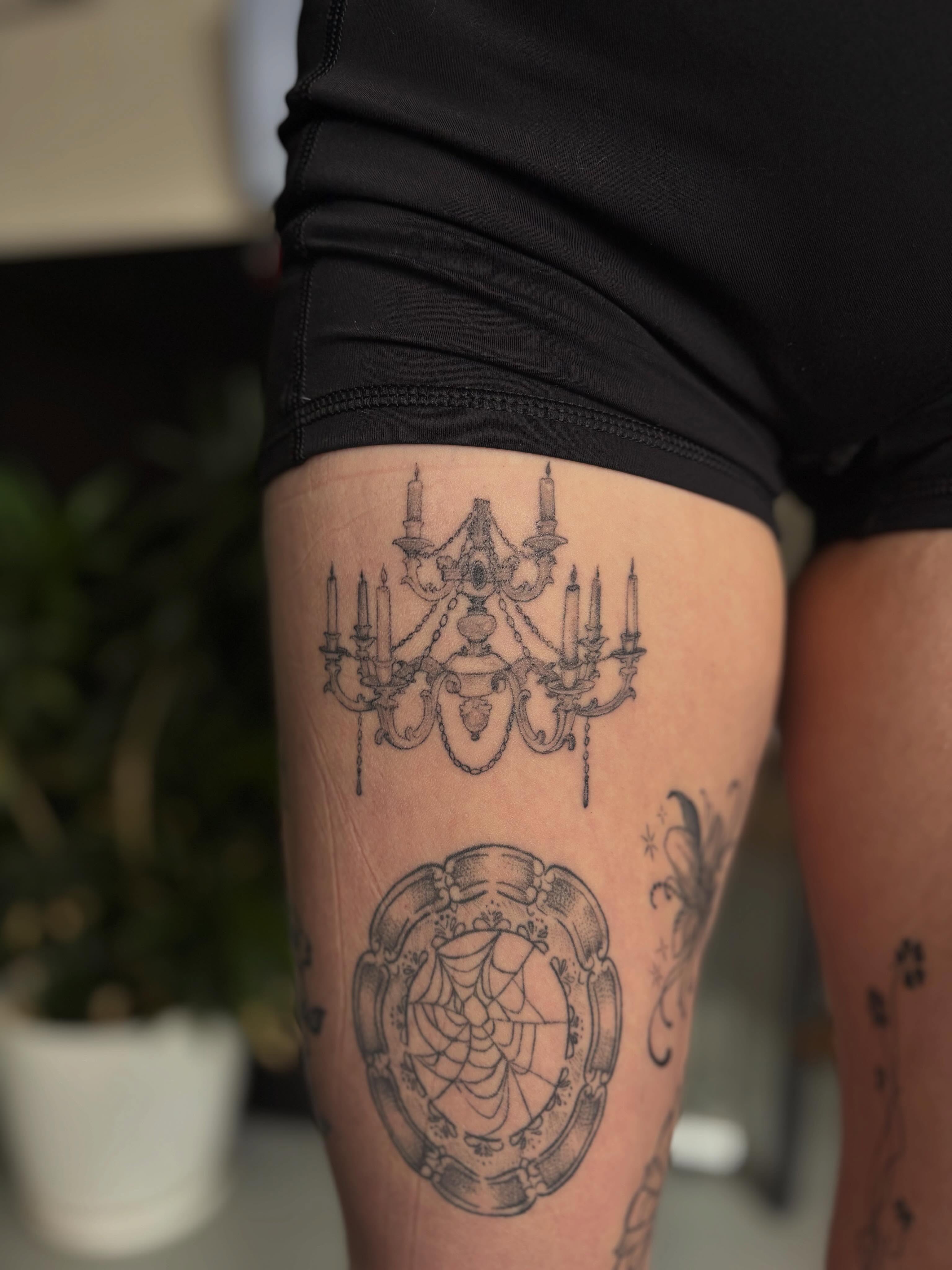 Chandelier black and grey tattoo on the thigh by Marissa Whitaker