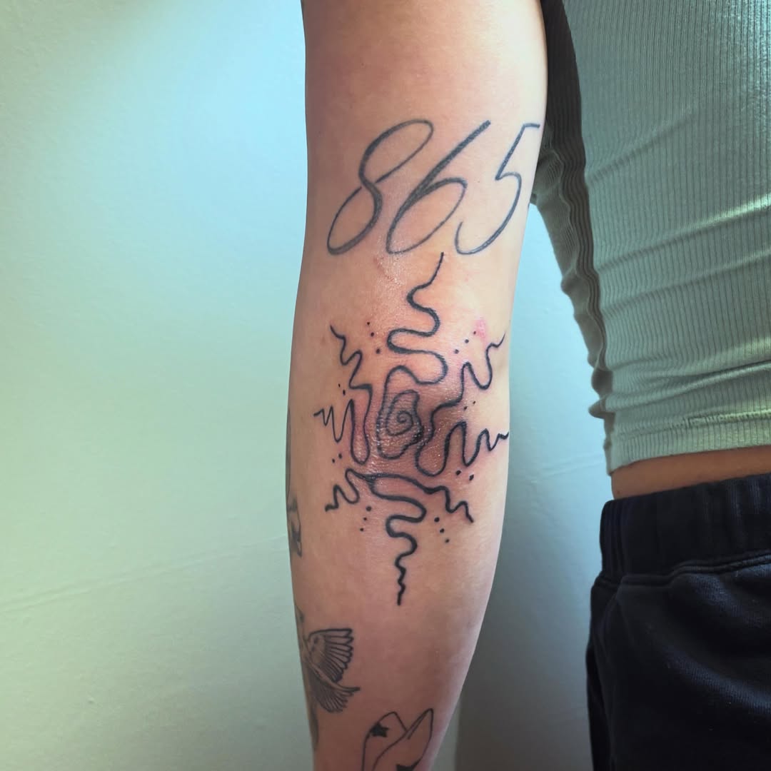 Numbers and abstract lines dotwork tattoo on the forearm by Natalie Jade Shupe