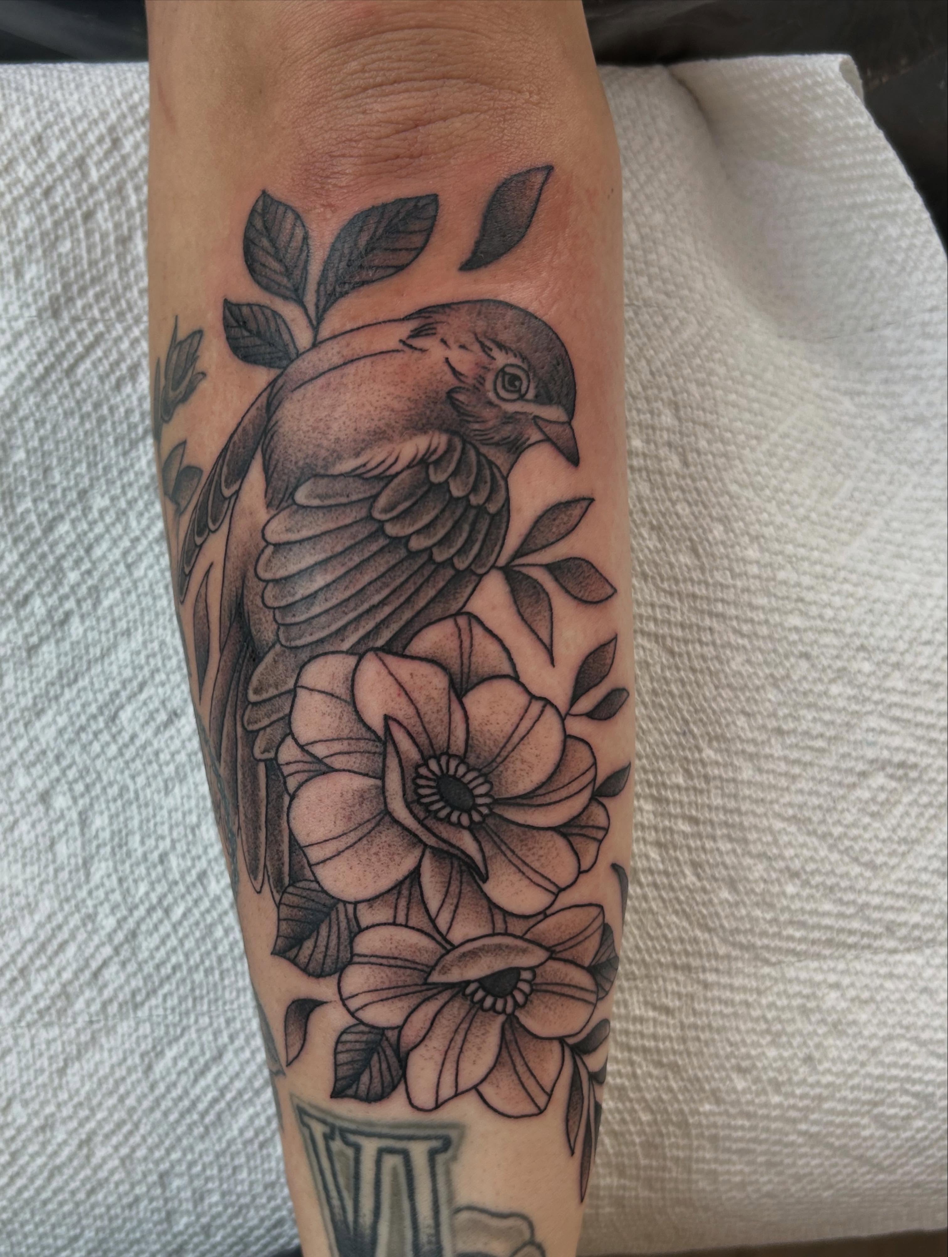 Bird and flowers realism tattoo on the forearm by Randy Bray