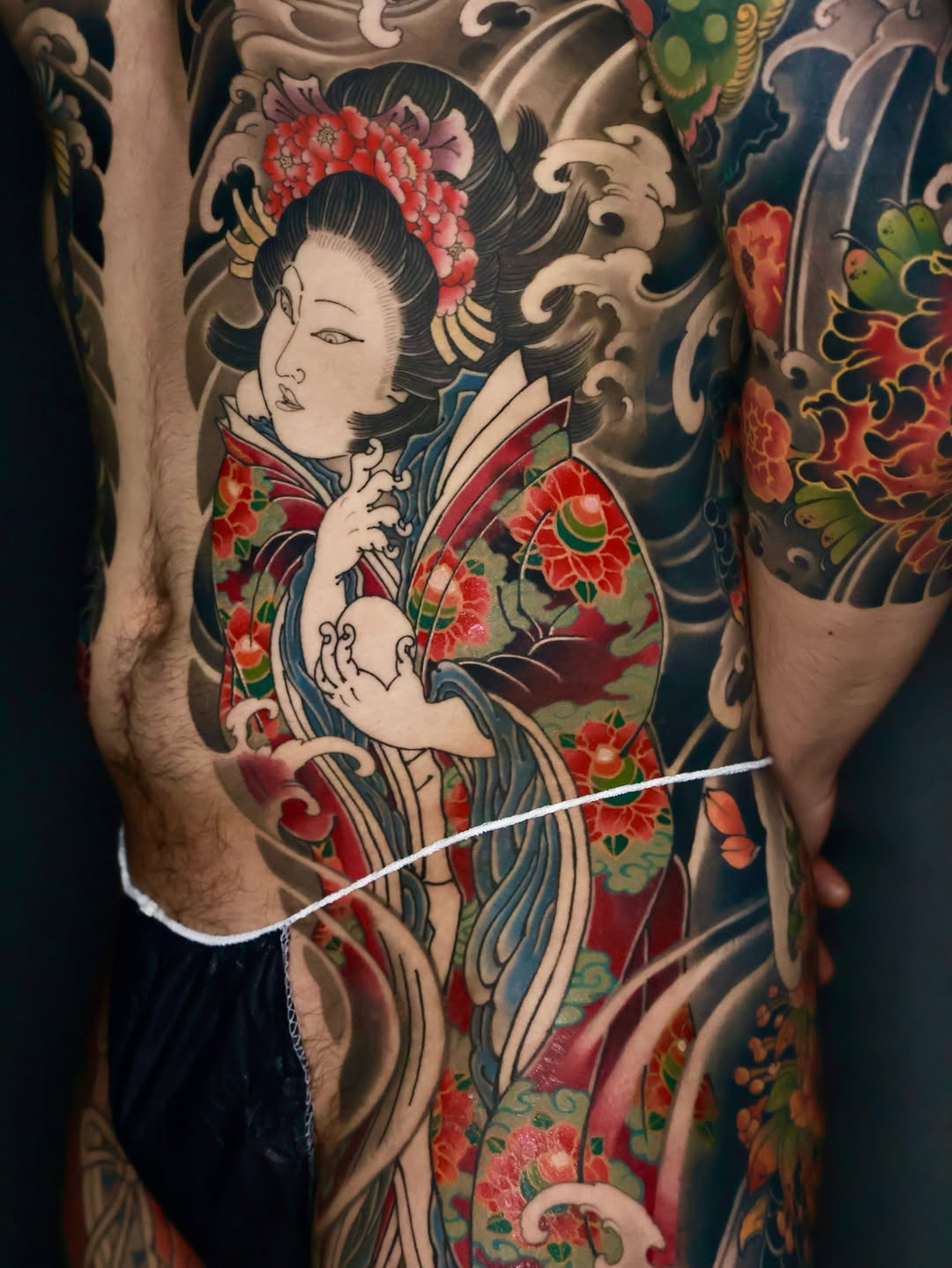 Geisha with flowers and waves Japanese tattoo on the thigh by Hocheon