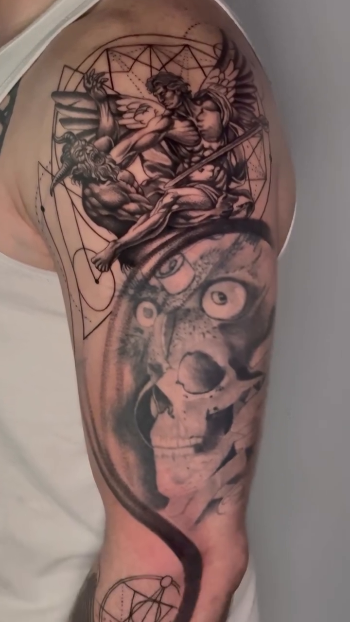Cherub and skull sleeve realism tattoo on the upper arm by Tattoo Artist Vanessa