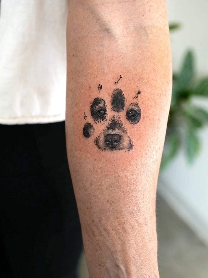 Dog paw print with dog face realism tattoo on the forearm by Ria Kim 김리아