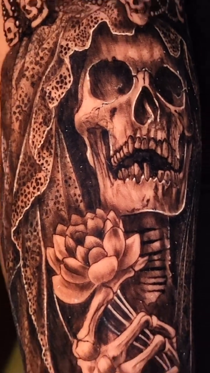 Grim reaper with lotus flower realism tattoo on the upper arm by Pod Viñes