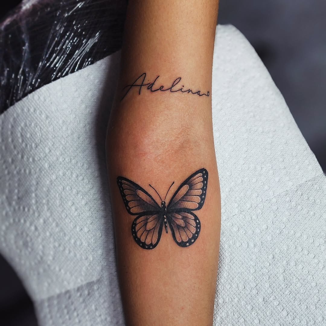 Butterfly and script lettering fine line tattoo on the forearm by Kai_Tattoo