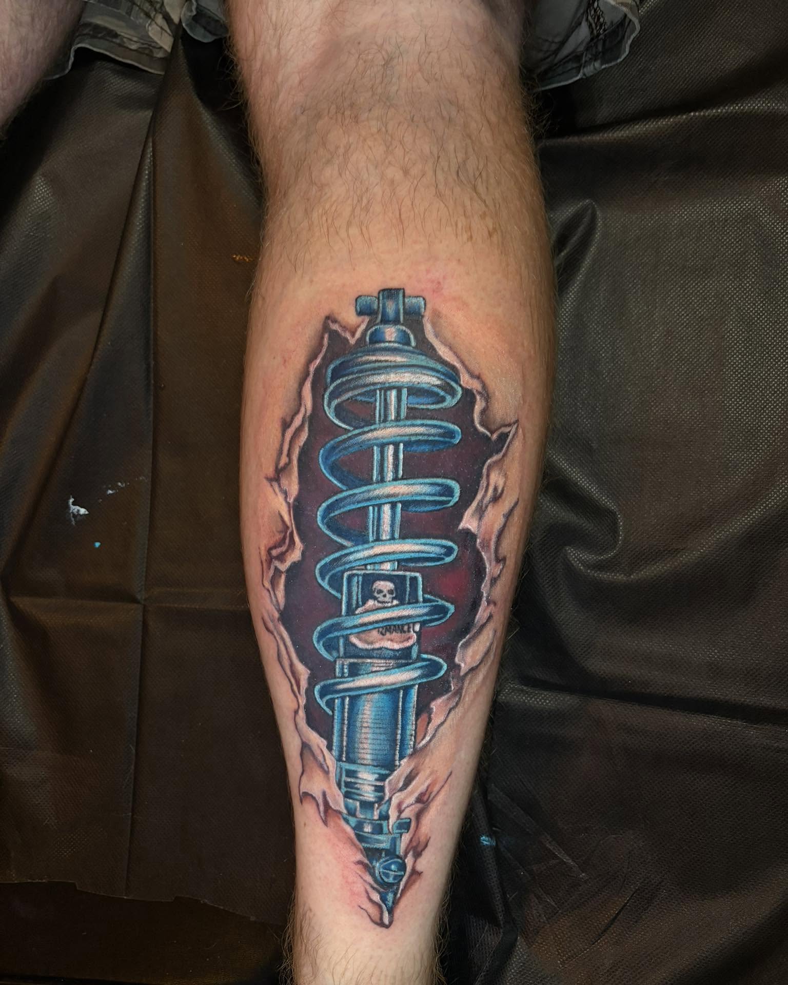 Shock absorber realism tattoo on the forearm by Rachel Sellers
