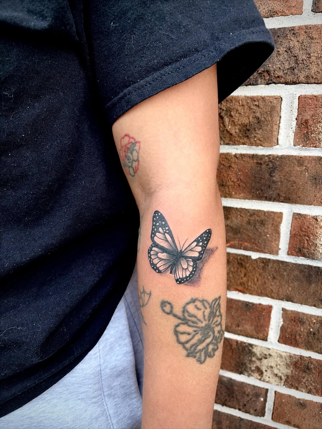 Monarch butterfly fine line tattoo on the forearm by Emily Farnsworth