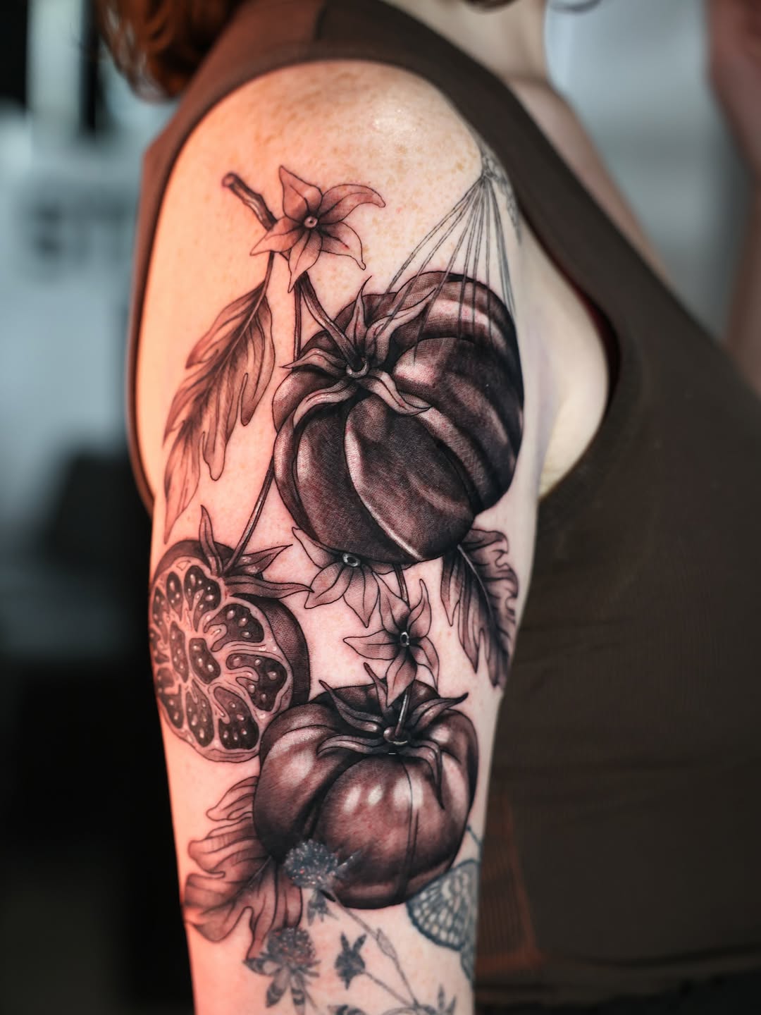 Tomatoes and pomegranate sketch tattoo on the upper arm by Charlotte Tattoo Artist