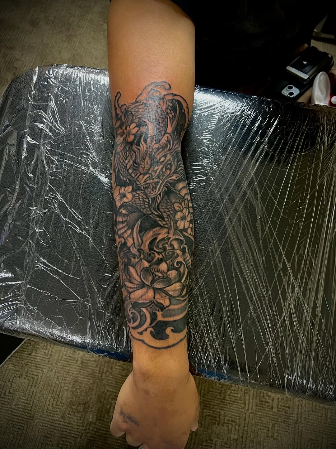 Dragon and lotus flowers Japanese tattoo on the forearm by Jelani