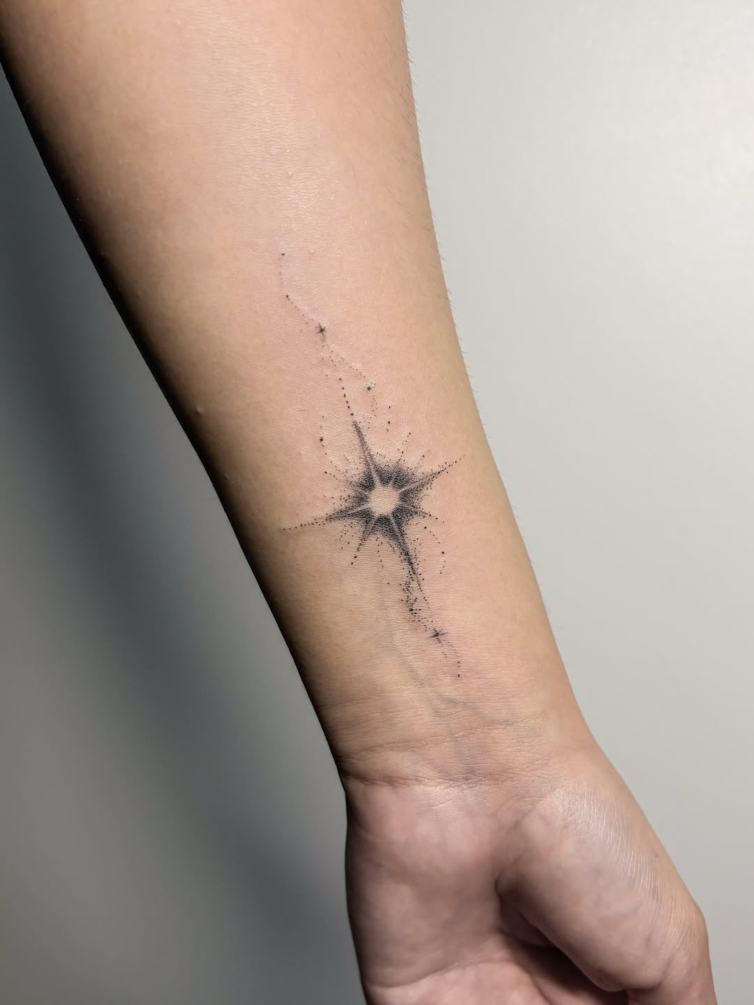 Starburst with trail sketch tattoo on the forearm by Jinz
