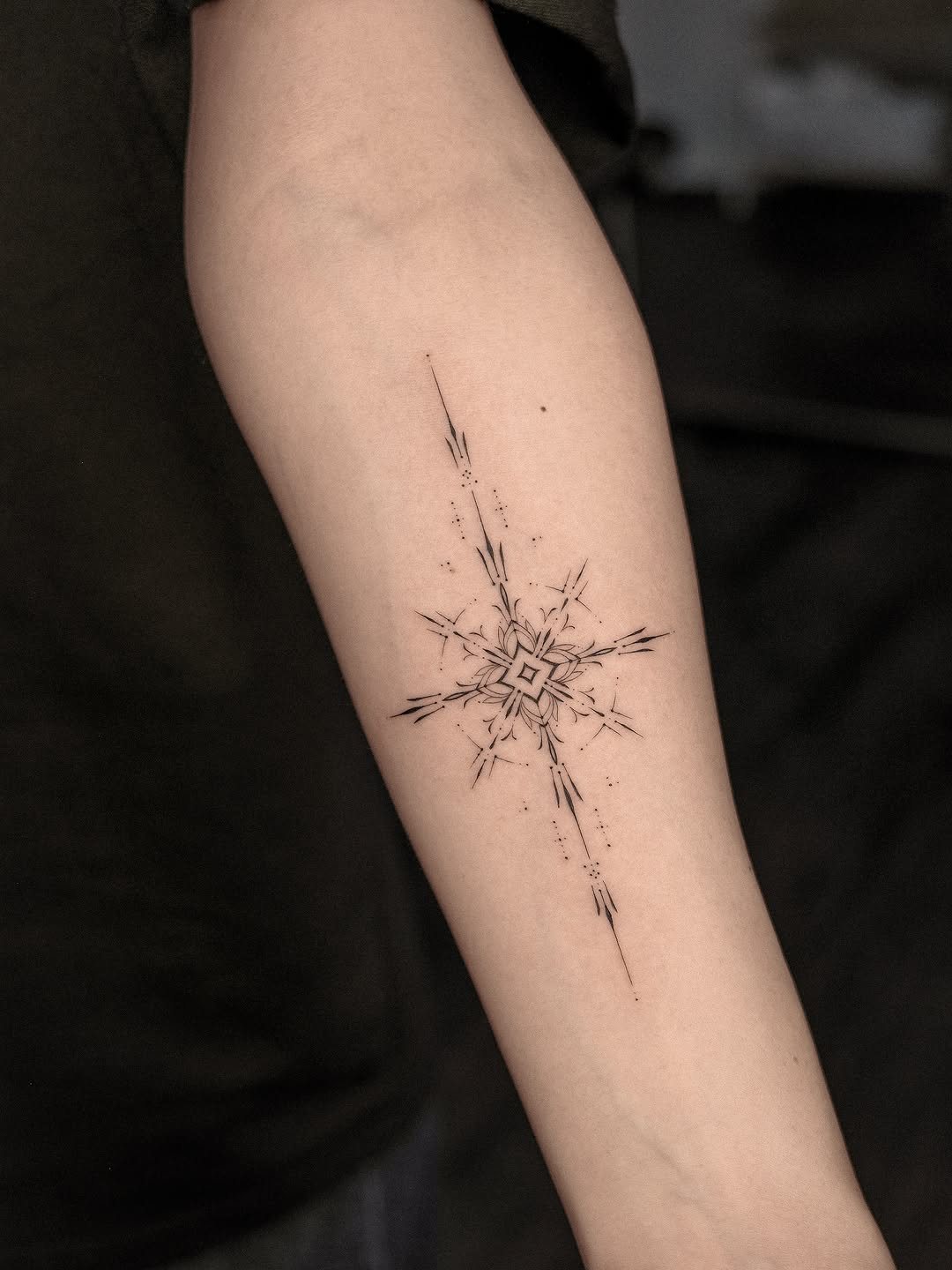 Geometric starburst ornamental tattoo on the forearm by Easy