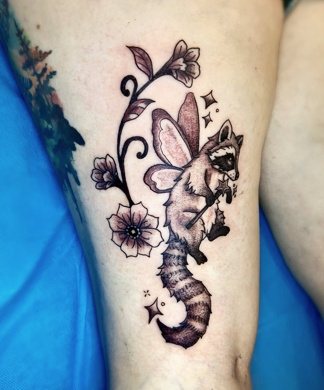 Fairy raccoon with flowers fine line tattoo on the forearm by Shay Cole