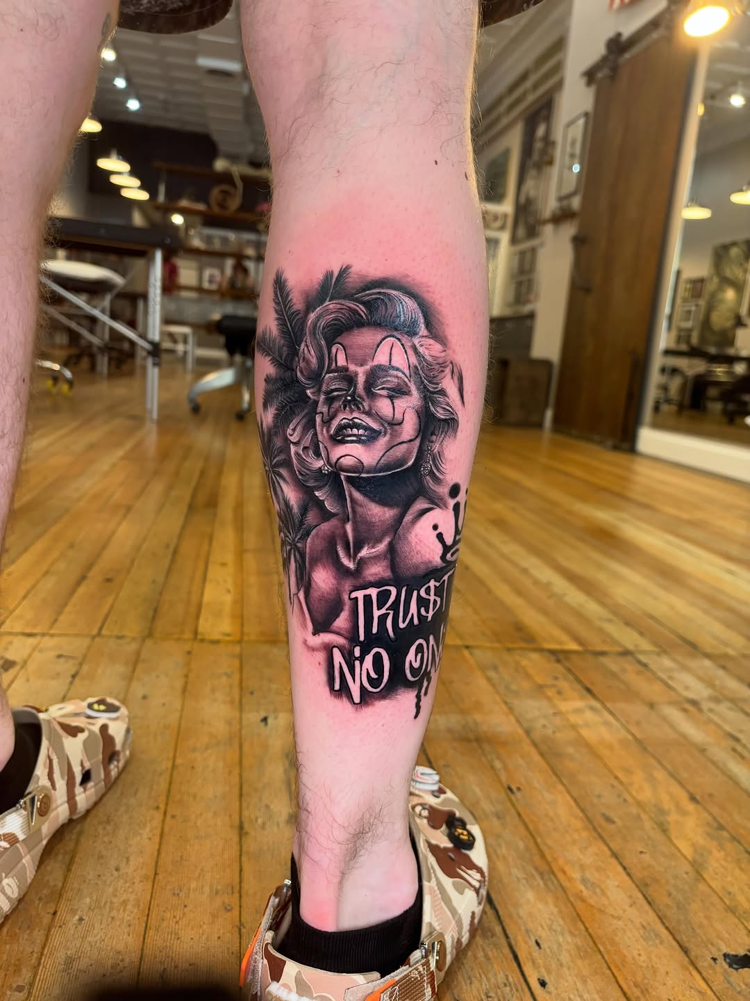 Clown portrait with lettering realism tattoo on the leg by Aubri Aunna