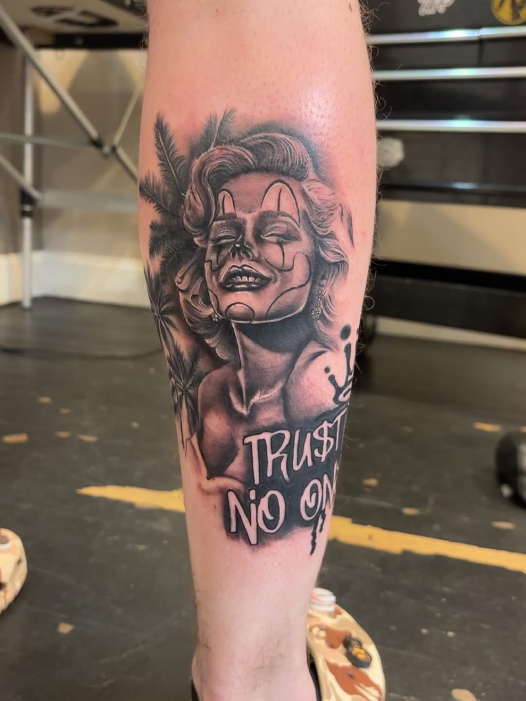 Woman with clown makeup and text realism tattoo on the forearm by Aubri Aunna