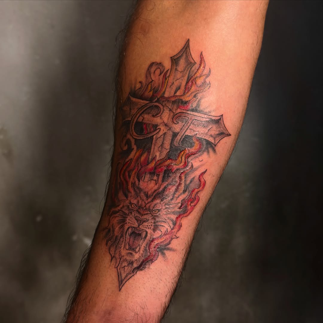 Cross with lion and flames realism tattoo on the forearm by 𝙸𝚗𝚔𝚊𝚗𝚍𝚕𝚒𝚕𝚢𝚜 🤎💉🐻🌸