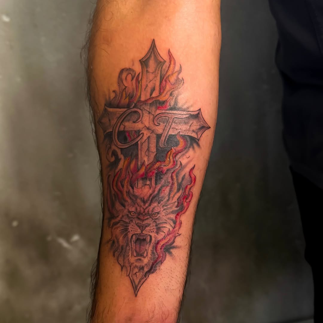 Cross with lion and flames realism tattoo on the forearm by 𝙸𝚗𝚔𝚊𝚗𝚍𝚕𝚒𝚕𝚢𝚜 🤎💉🐻🌸