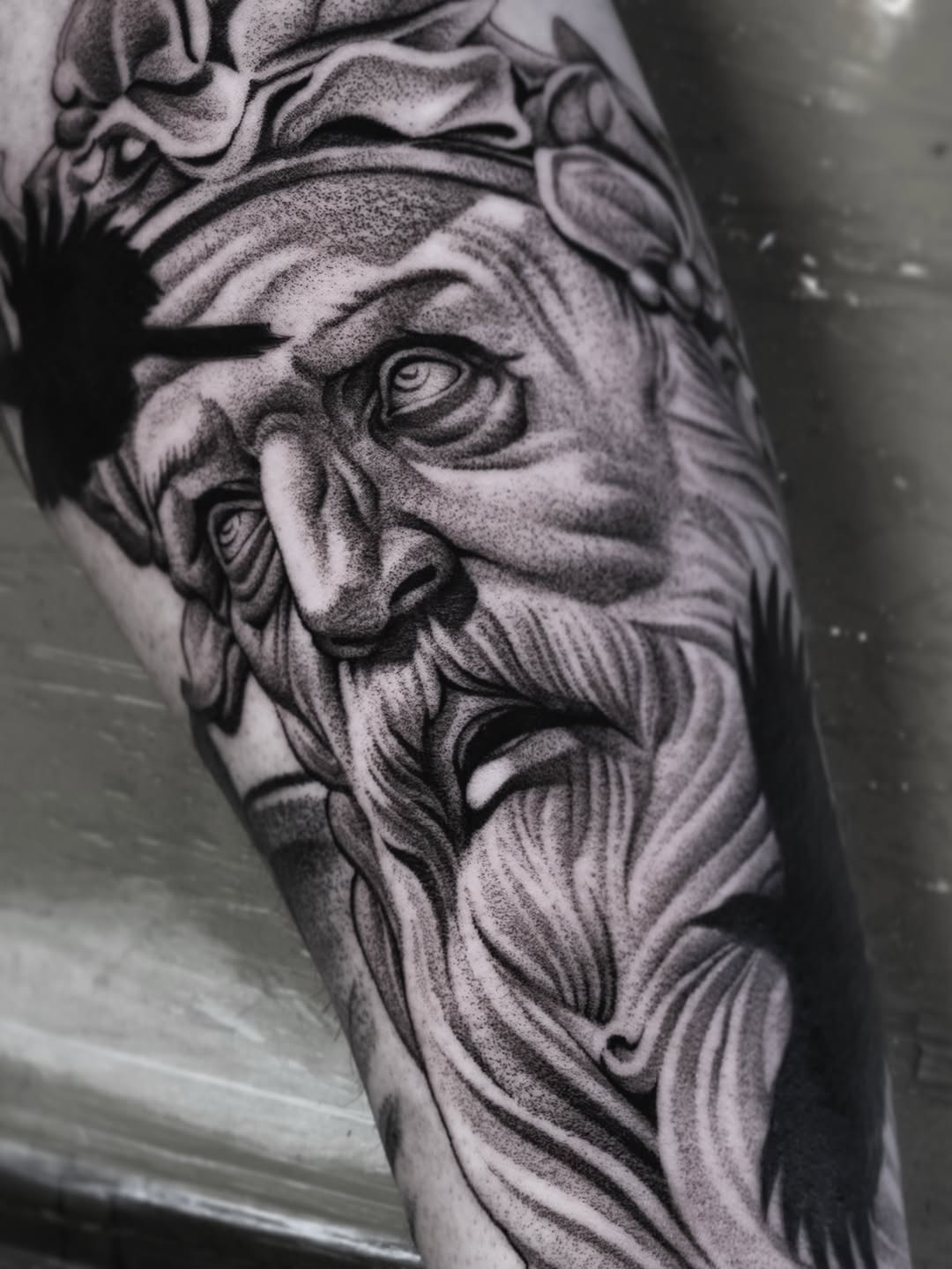 Old man's face with crow surrealism tattoo on the forearm by Craig St Peter, Kansas City, Missouri