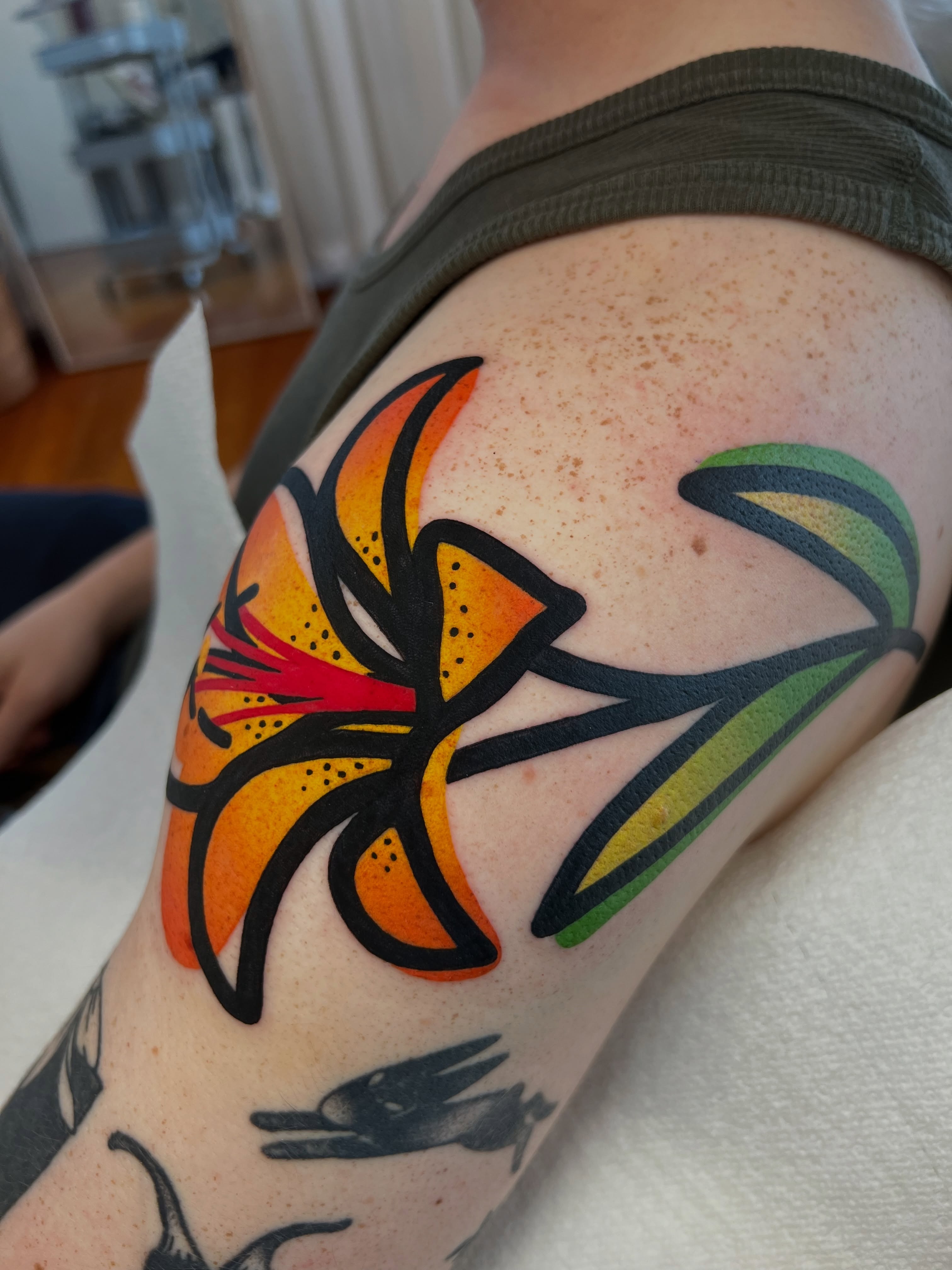 Lily flower dotwork tattoo on the upper arm by Tattoo Artist