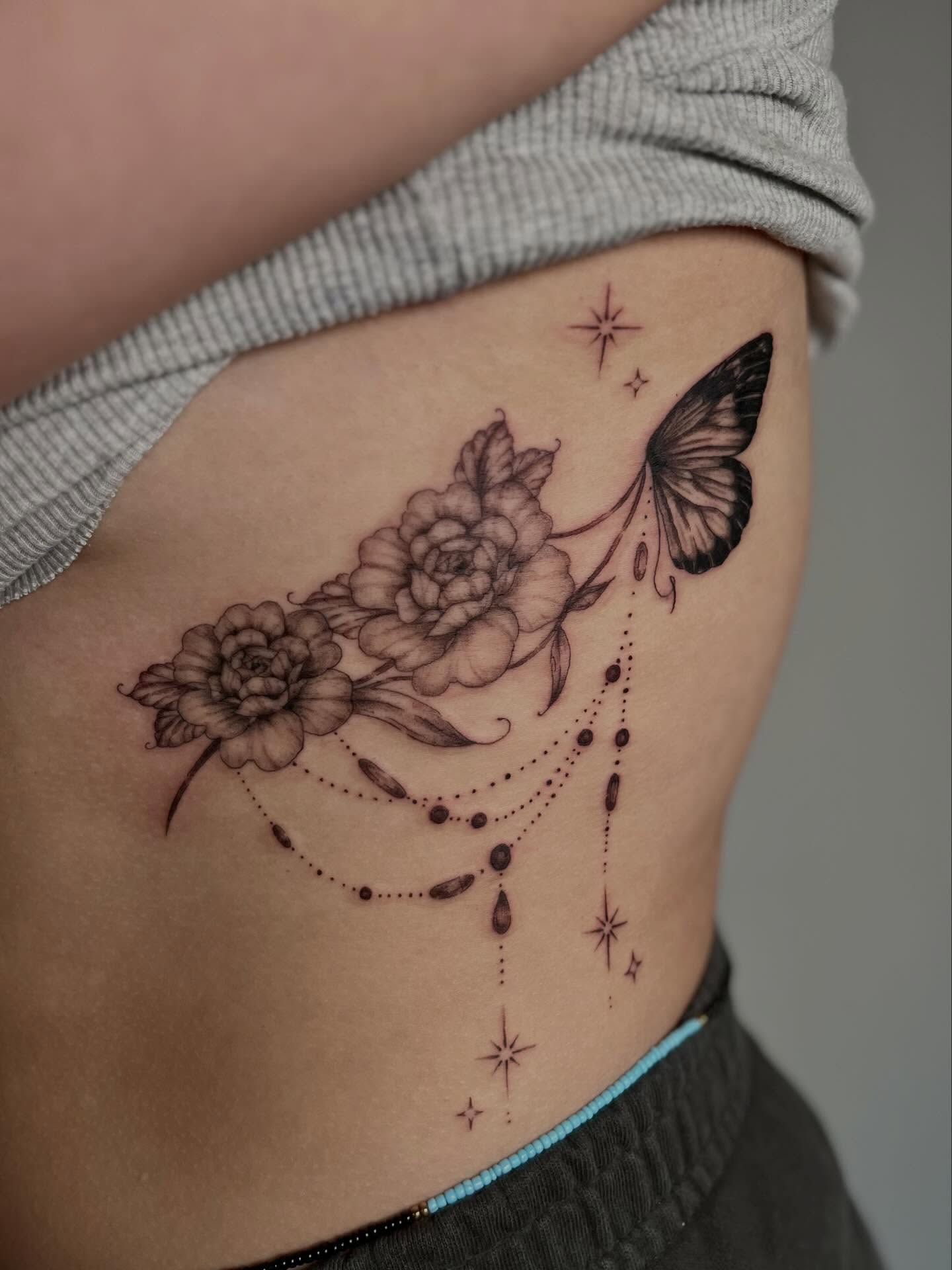 Flowers and butterfly dotwork tattoo on the ribs by Cat girl tattoo