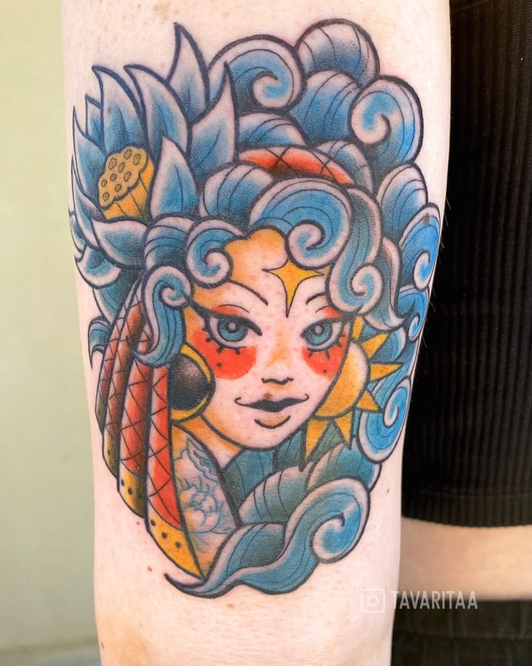 Woman's face with lotus and waves neo-traditional tattoo on the forearm by Tavarita