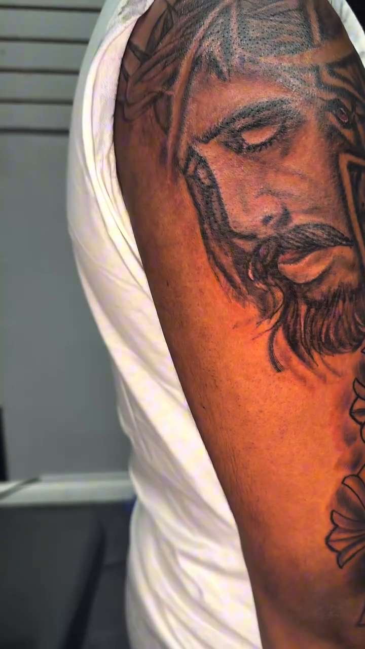 Chicano tattoo on the upper arm by 2PaidTattz