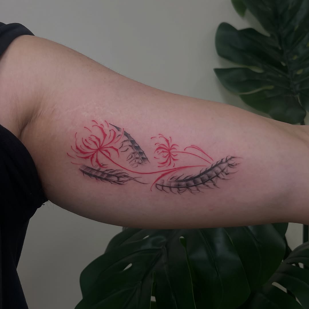 Spider lilies and centipede watercolor tattoo on the forearm by David